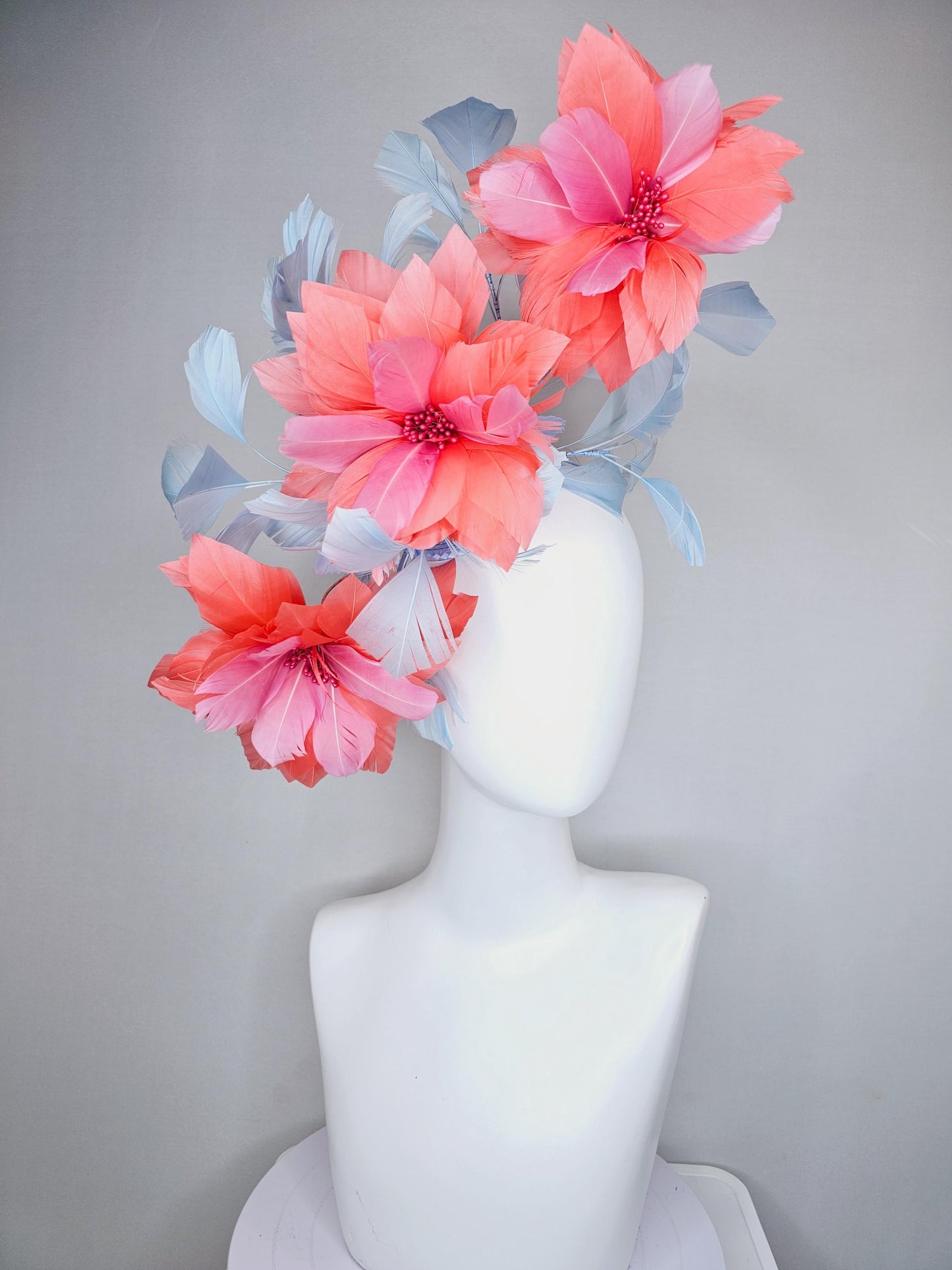 kentucky derby hat fascinator with large coral orange light pink feather flowers and light baby blue branching feathers