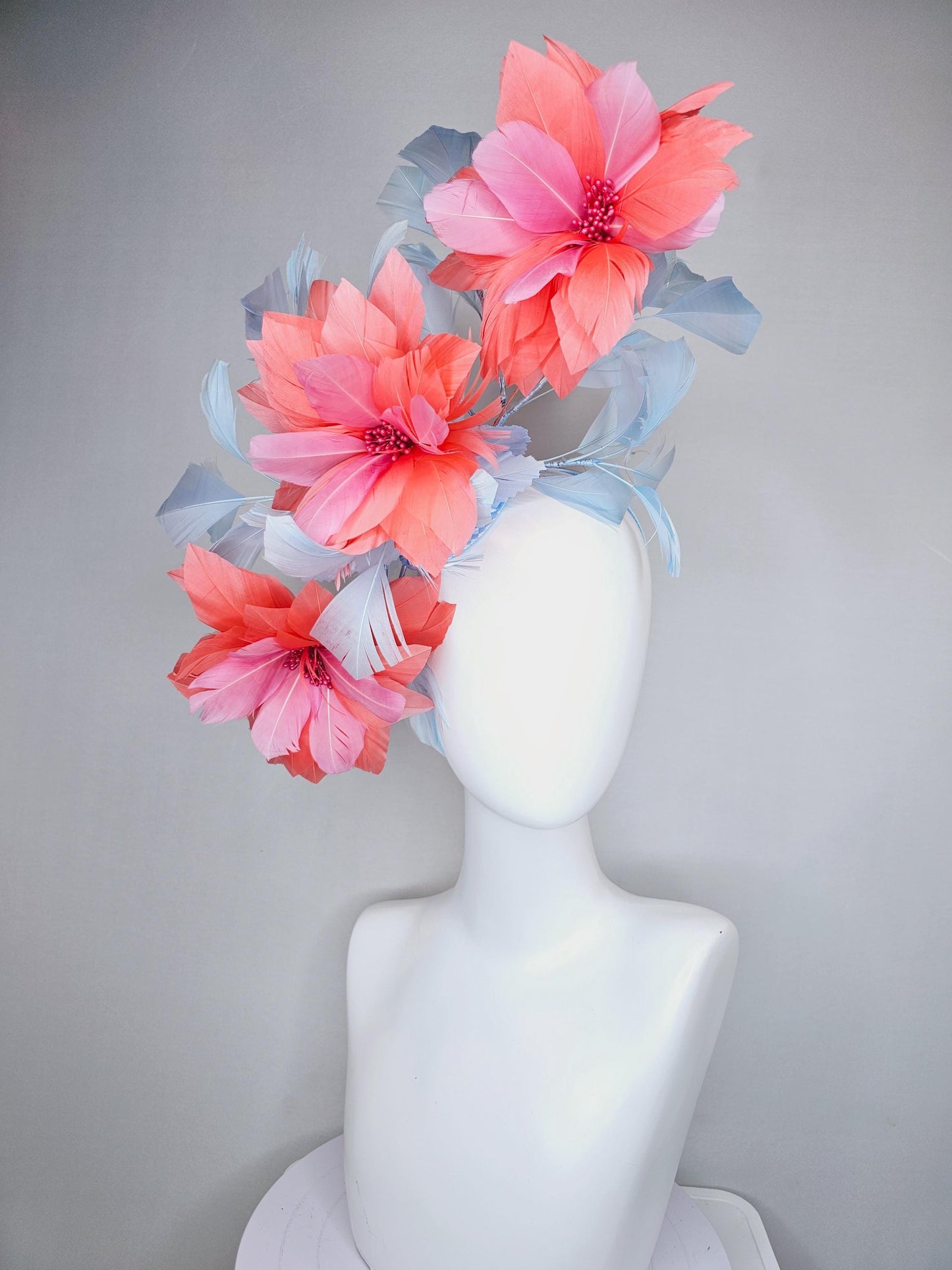 kentucky derby hat fascinator with large coral orange light pink feather flowers and light baby blue branching feathers