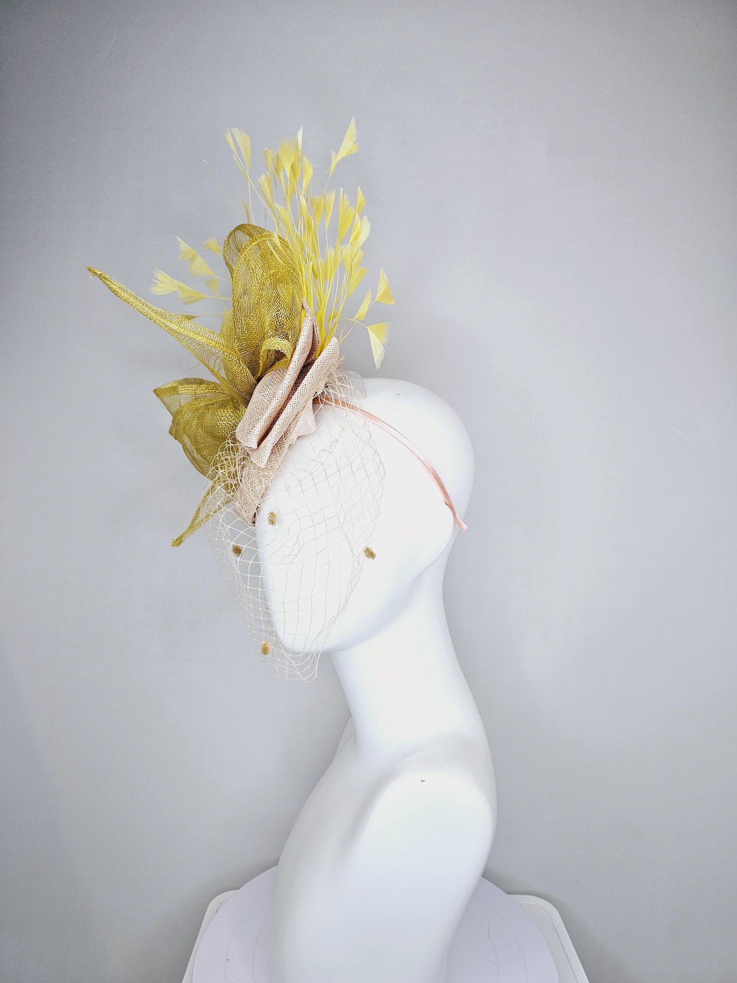 kentucky derby hat fascinator neutral beige sinamay with mesh veil, large mustard yellow mesh ribbon bow, light yellow branching feathers