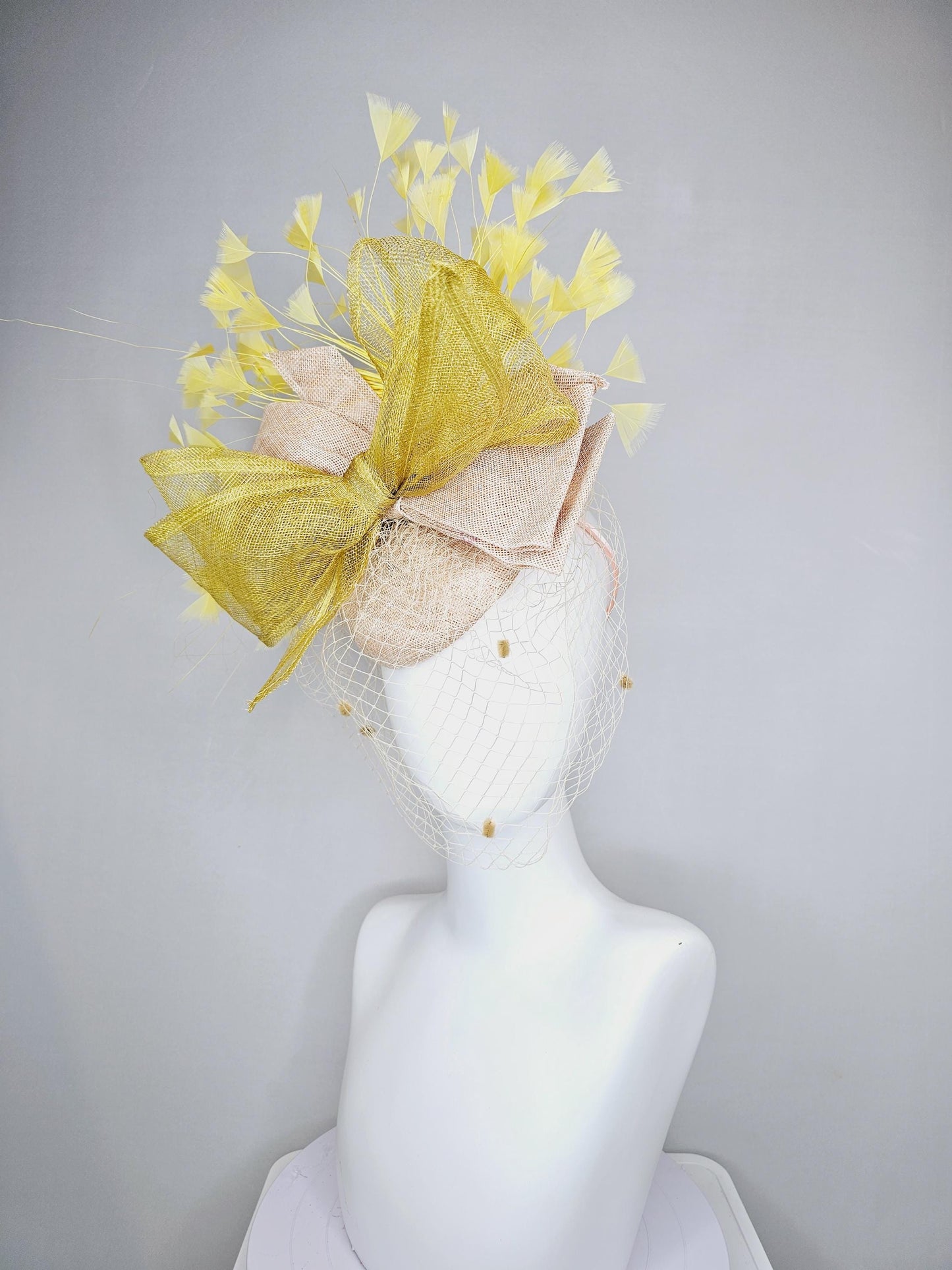 kentucky derby hat fascinator neutral beige sinamay with mesh veil, large mustard yellow mesh ribbon bow, light yellow branching feathers