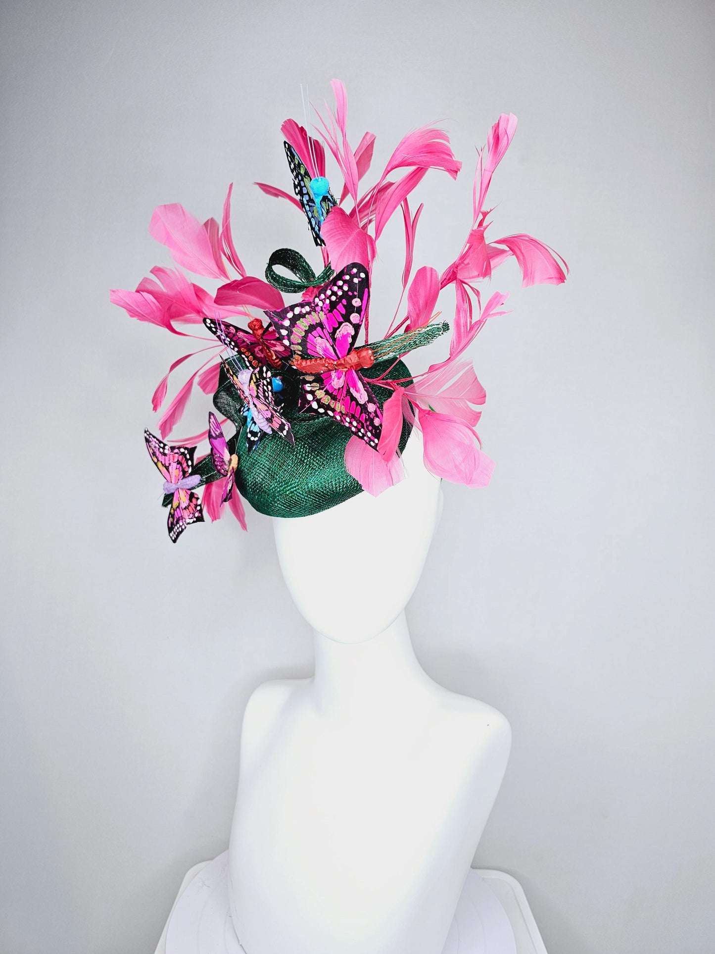 kentucky derby hat fascinator dark green sinamay with curls,pink branching feathers,colorful rainbow blue,pink,purple painted butterflies