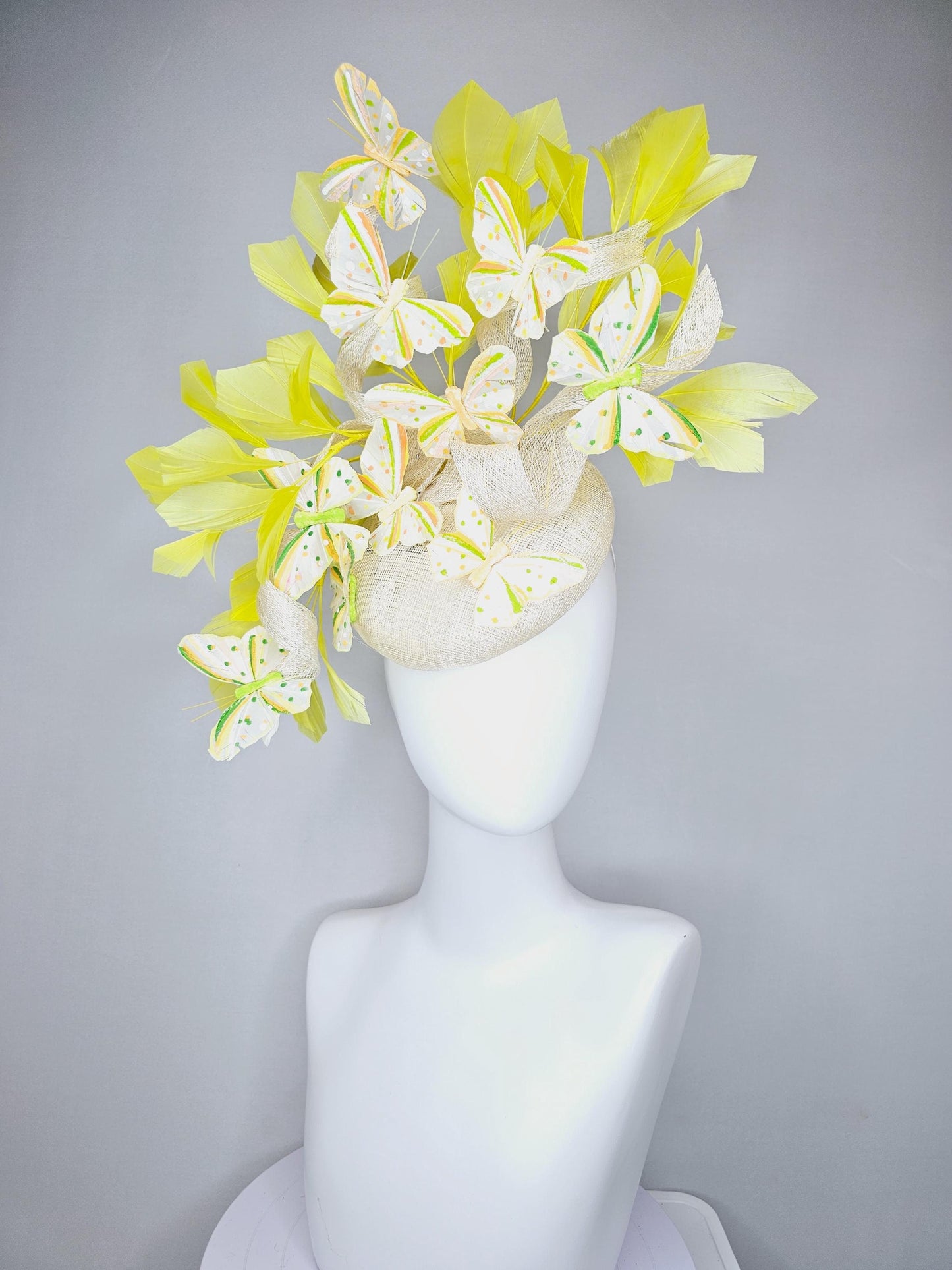 kentucky derby hat fascinator white sinamay with large curls,yellow branching feathers and green,yellow,orange dotted feather butterflies