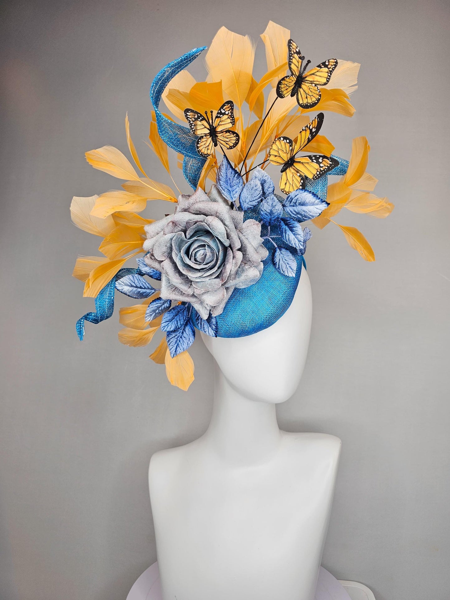 kentucky derby hat fascinator blue sinamay w/ curls,blue purple ombre rose,blue leaves,apricot orange yellow feathers w/ apricot butterflies