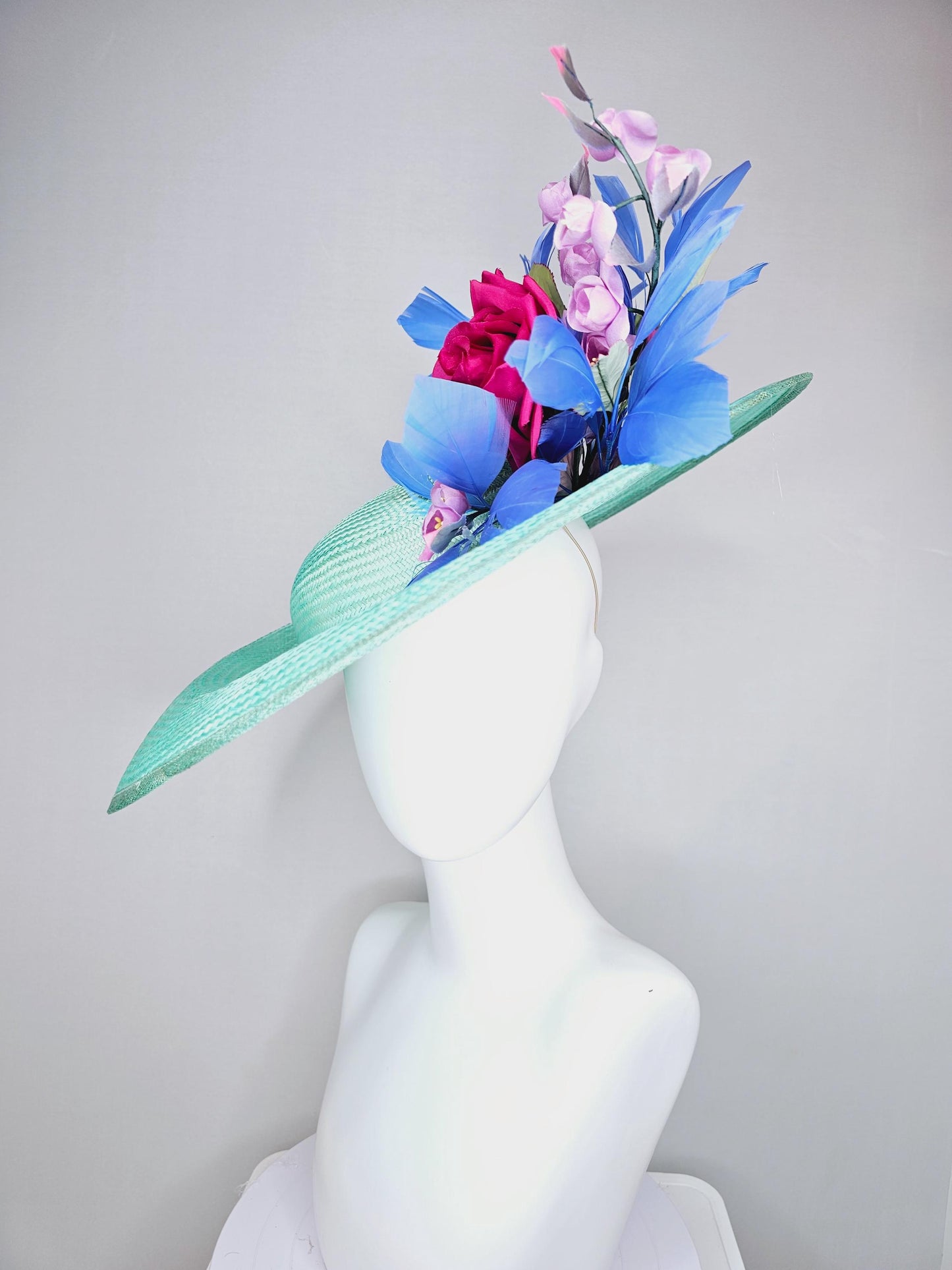 kentucky derby hat wide brim straw in aqua mint green with pink satin rose and lilac lavender purple satin rose stems cobalt blue feathers