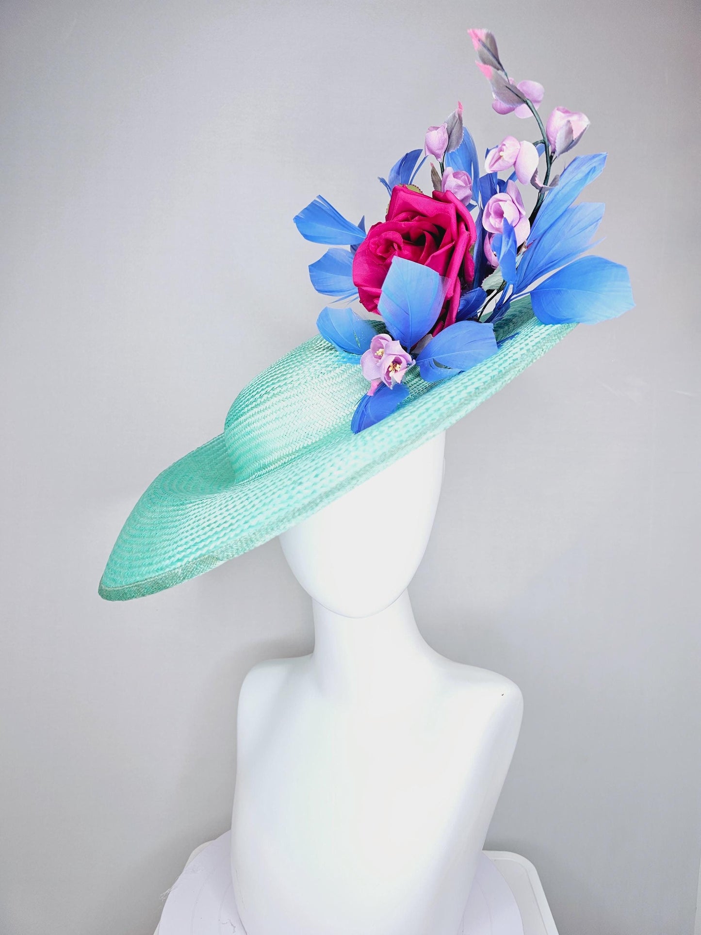 kentucky derby hat wide brim straw in aqua mint green with pink satin rose and lilac lavender purple satin rose stems cobalt blue feathers
