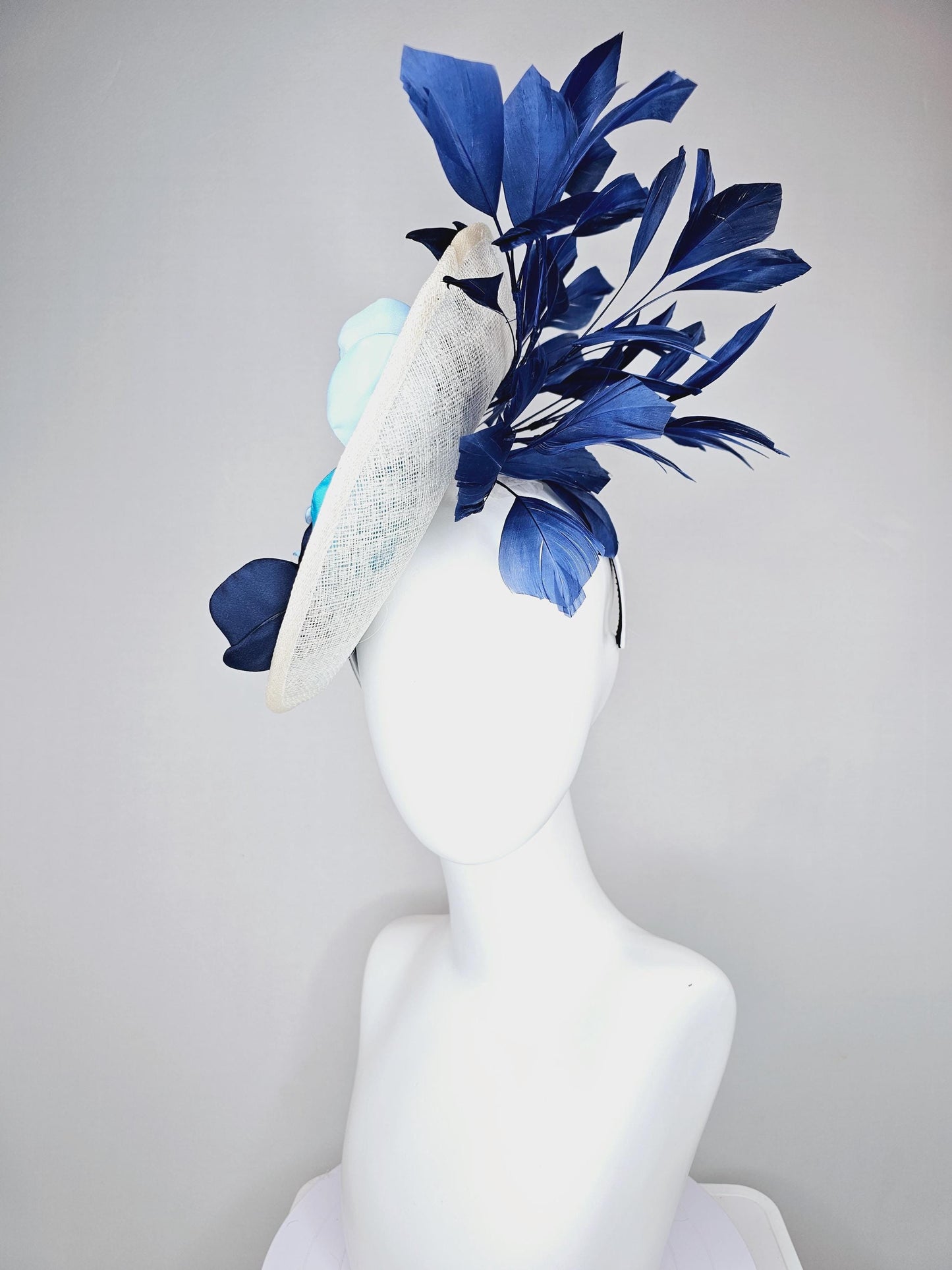 kentucky derby hat fascinator white sinamay saucer with light blue sky blue navy blue satin silk flowers and navy blue branching feathers