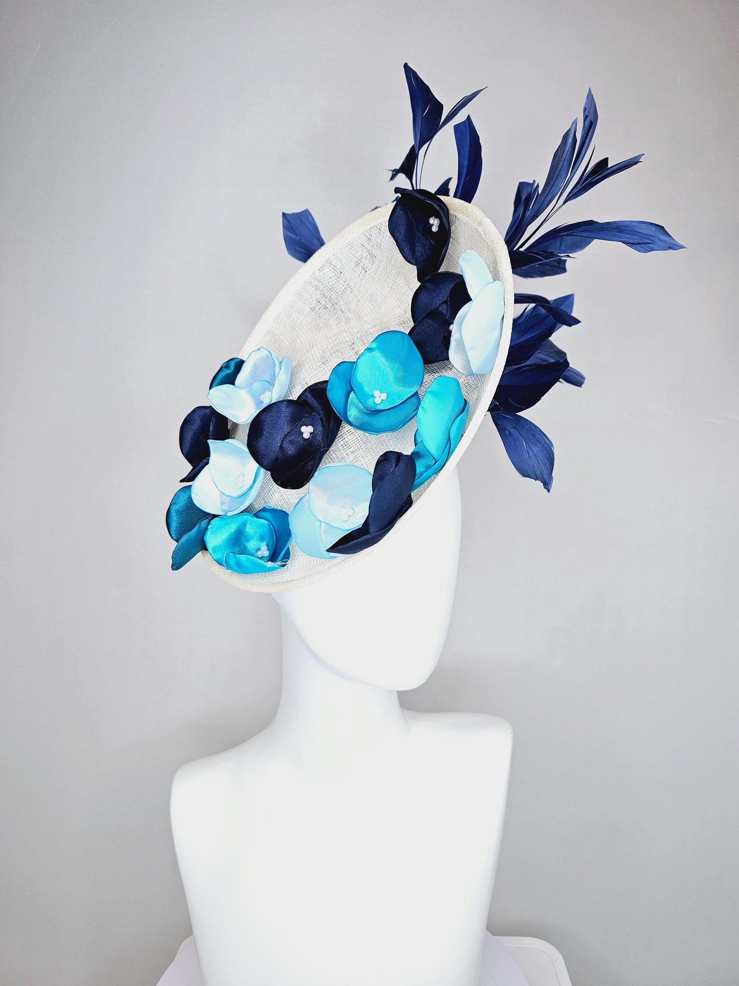 kentucky derby hat fascinator white sinamay saucer with light blue sky blue navy blue satin silk flowers and navy blue branching feathers