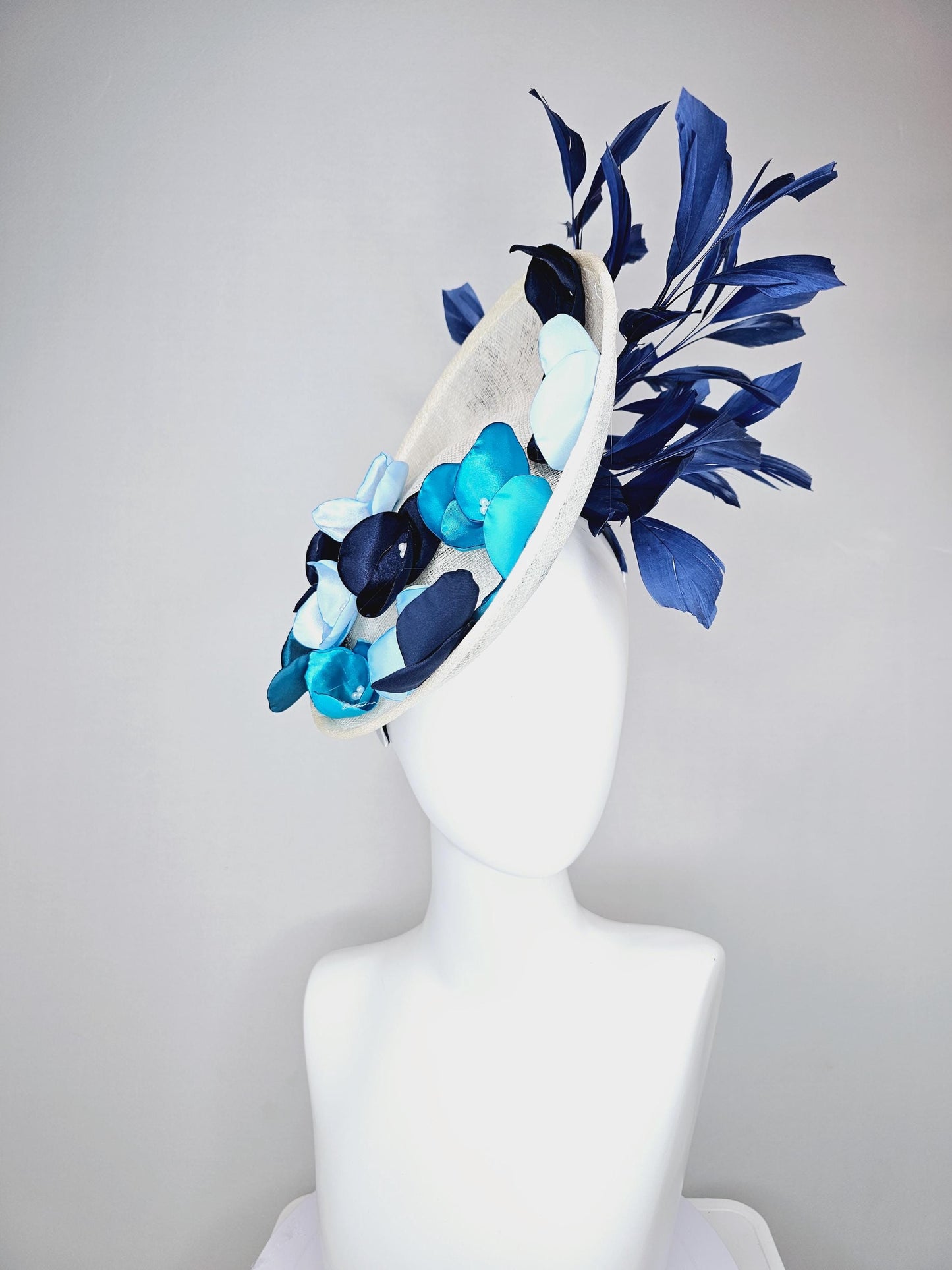 kentucky derby hat fascinator white sinamay saucer with light blue sky blue navy blue satin silk flowers and navy blue branching feathers