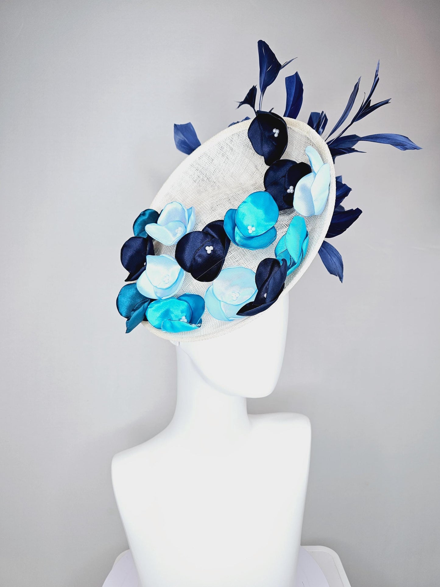 kentucky derby hat fascinator white sinamay saucer with light blue sky blue navy blue satin silk flowers and navy blue branching feathers