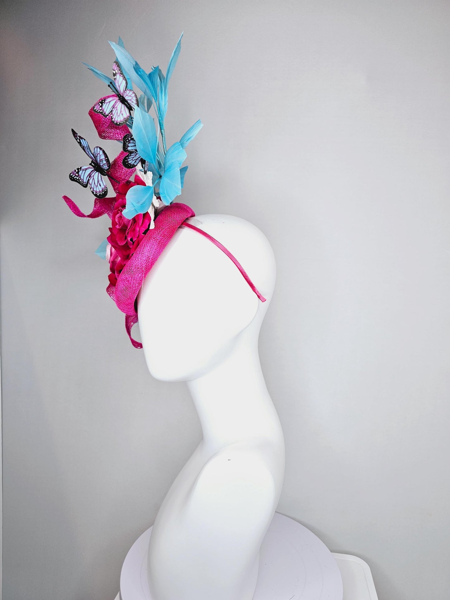 kentucky derby hat fascinator fuchsia pink sinamay with curls,ombre fuchsia pink satin roses,white leaves,sky blue feathers,blue butterflies