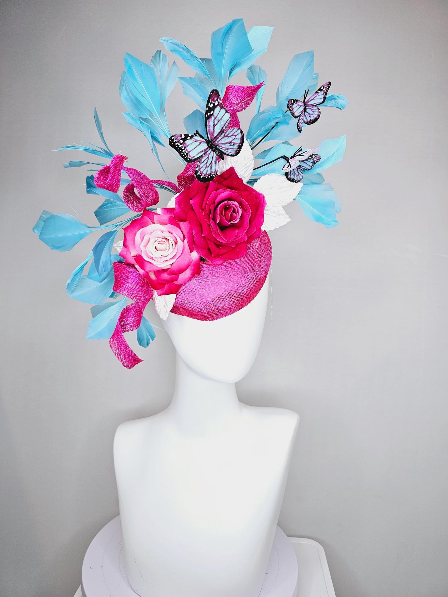 kentucky derby hat fascinator fuchsia pink sinamay with curls,ombre fuchsia pink satin roses,white leaves,sky blue feathers,blue butterflies