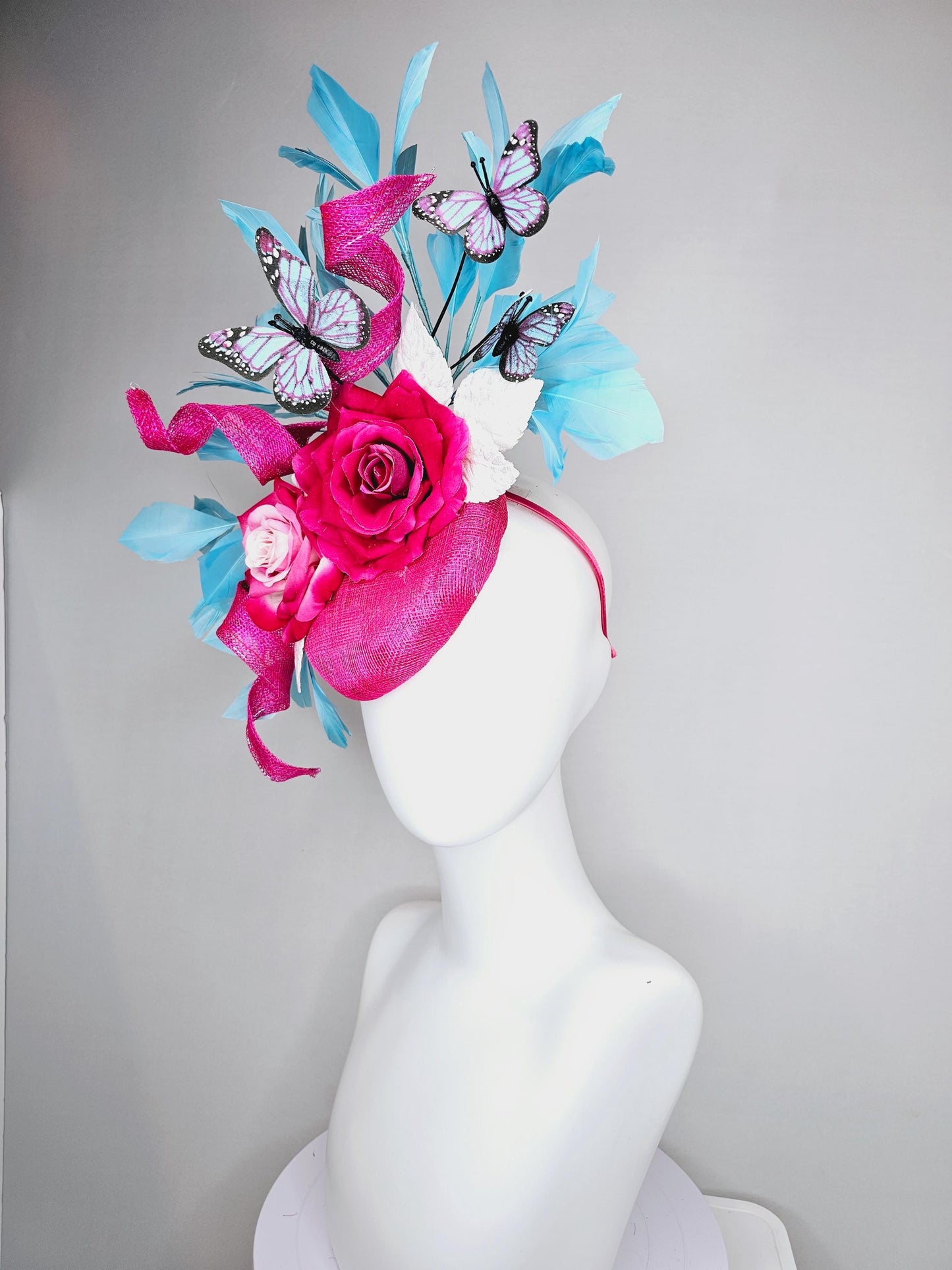 kentucky derby hat fascinator fuchsia pink sinamay with curls,ombre fuchsia pink satin roses,white leaves,sky blue feathers,blue butterflies