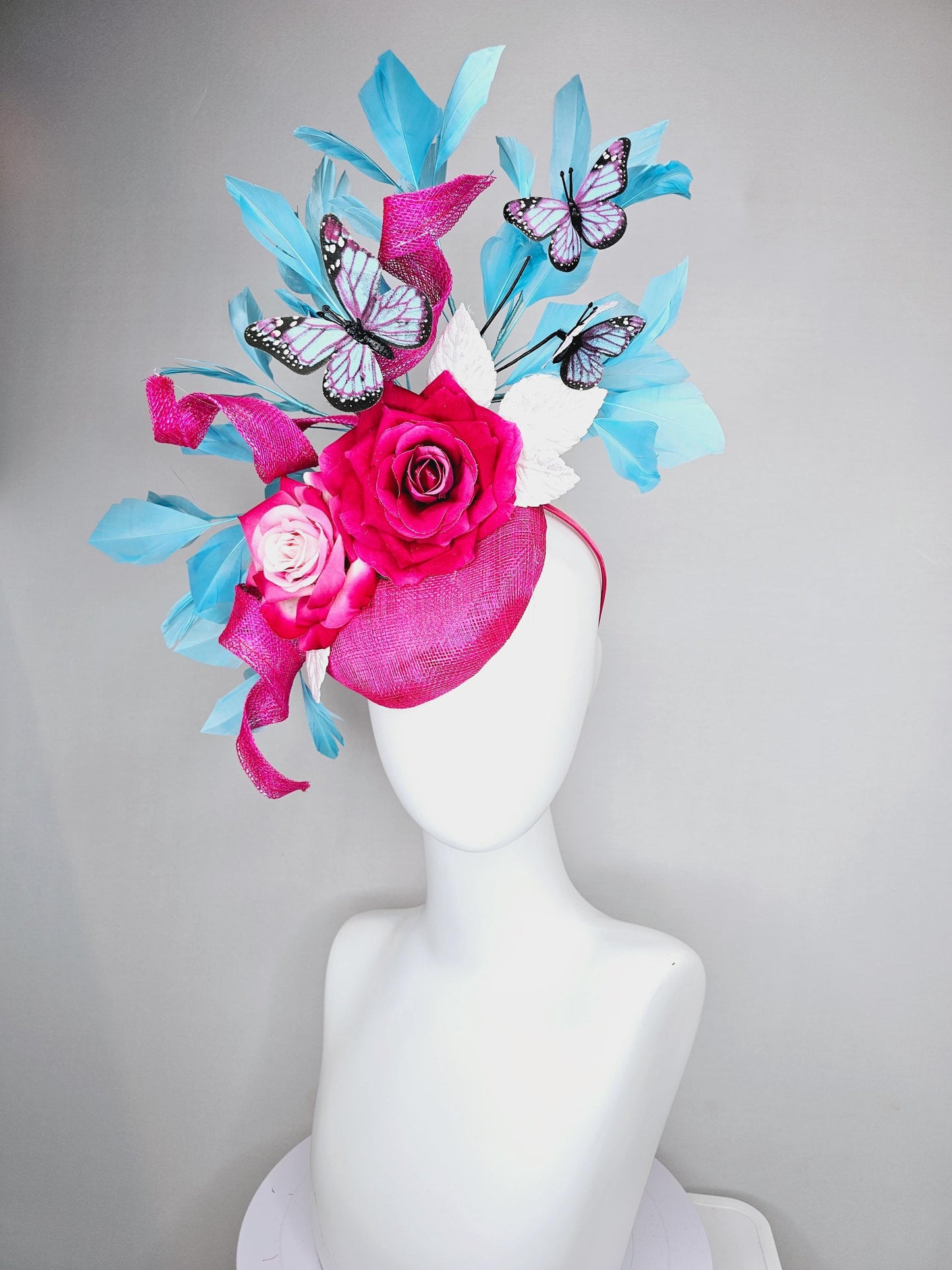 kentucky derby hat fascinator fuchsia pink sinamay with curls,ombre fuchsia pink satin roses,white leaves,sky blue feathers,blue butterflies