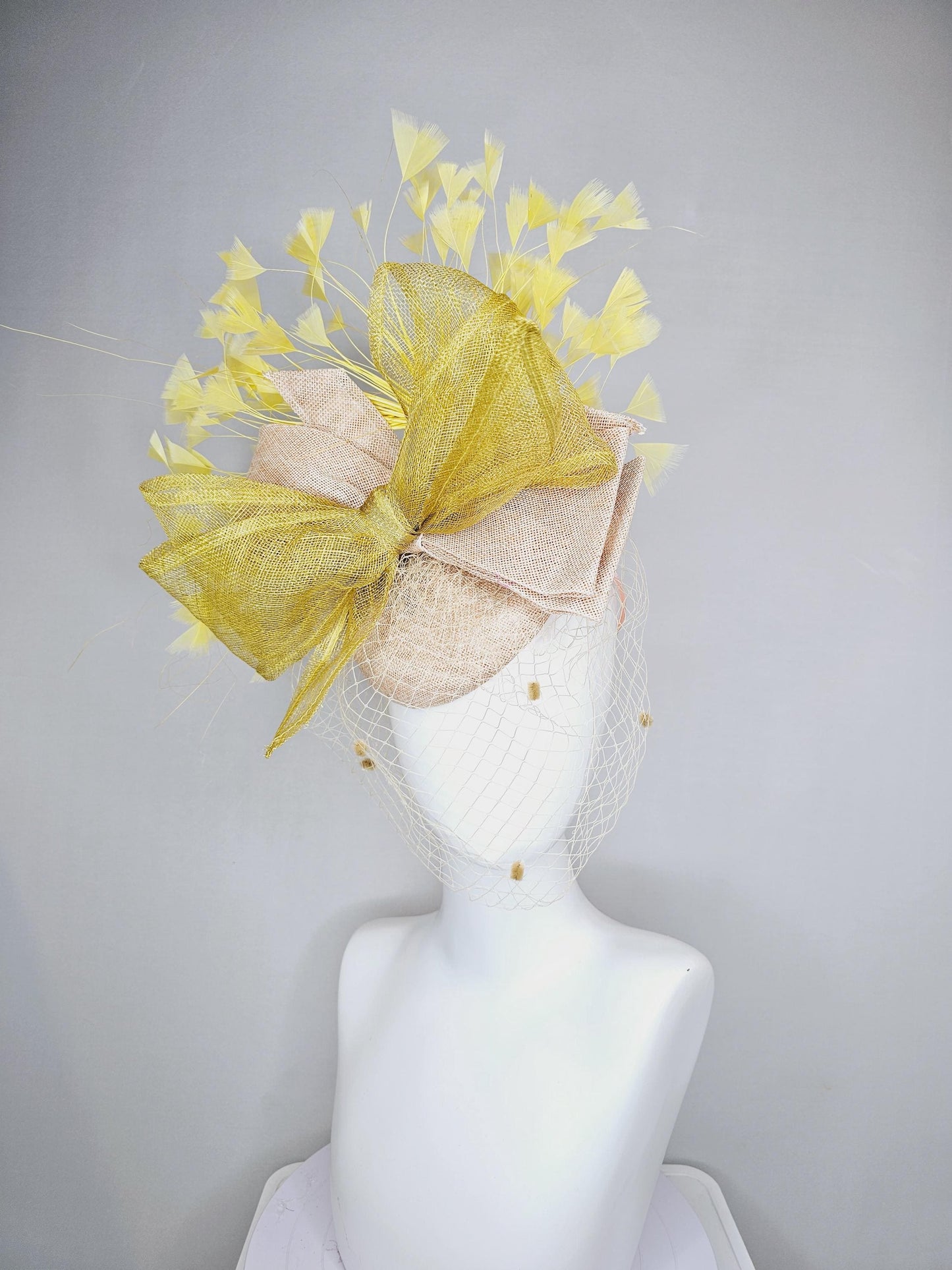 kentucky derby hat fascinator neutral beige sinamay with mesh veil, large mustard yellow mesh ribbon bow, light yellow branching feathers