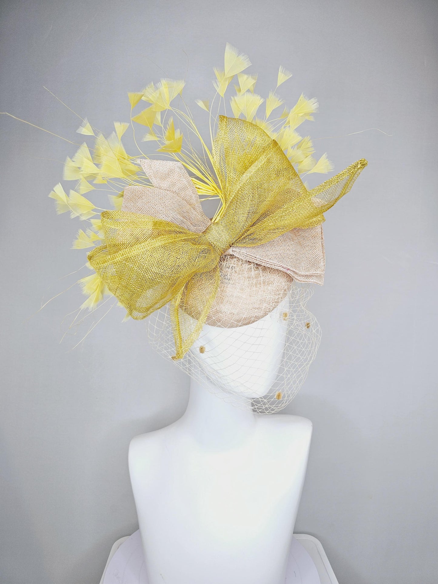 kentucky derby hat fascinator neutral beige sinamay with mesh veil, large mustard yellow mesh ribbon bow, light yellow branching feathers