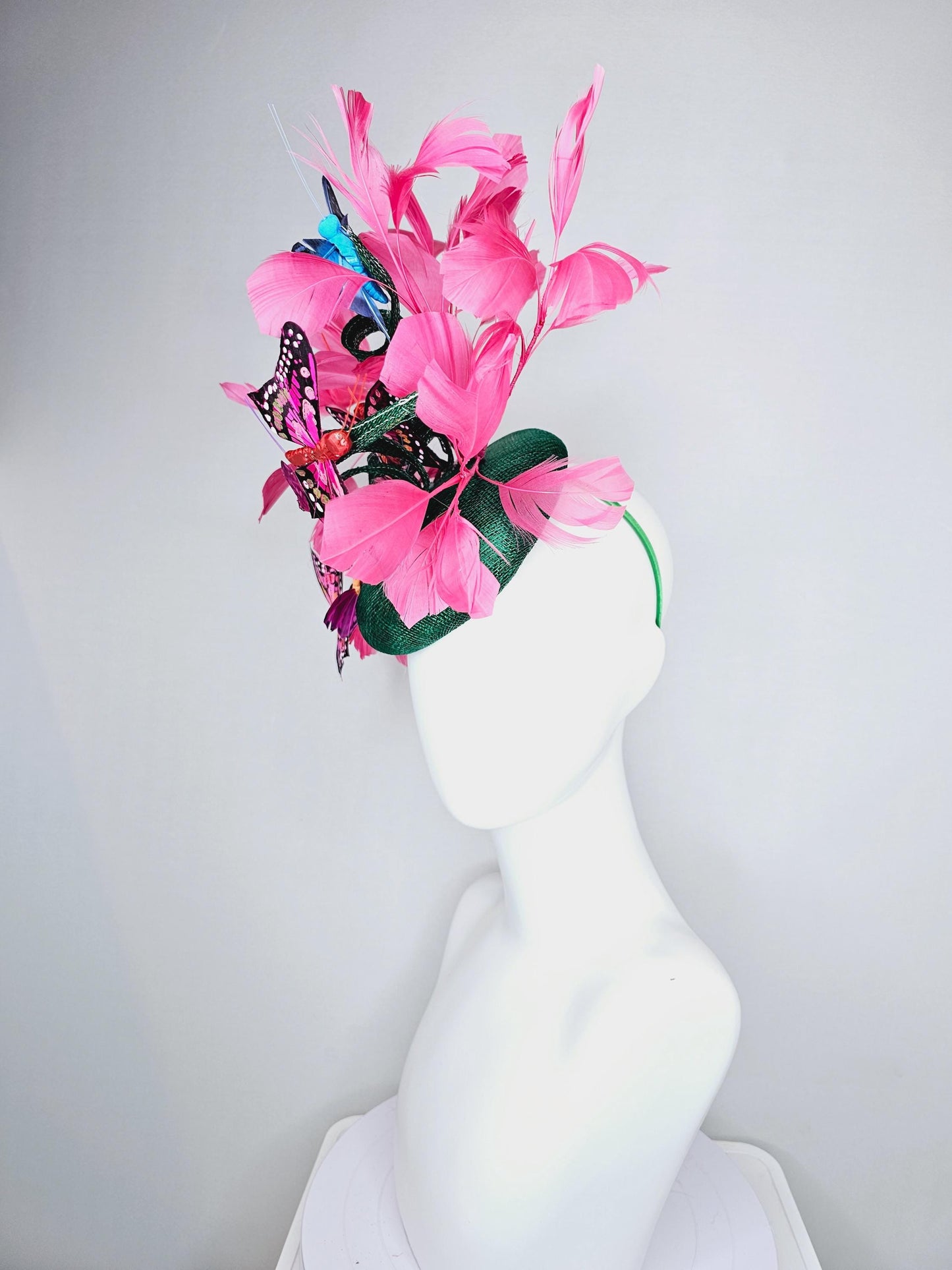 kentucky derby hat fascinator dark green sinamay with curls,pink branching feathers,colorful rainbow blue,pink,purple painted butterflies