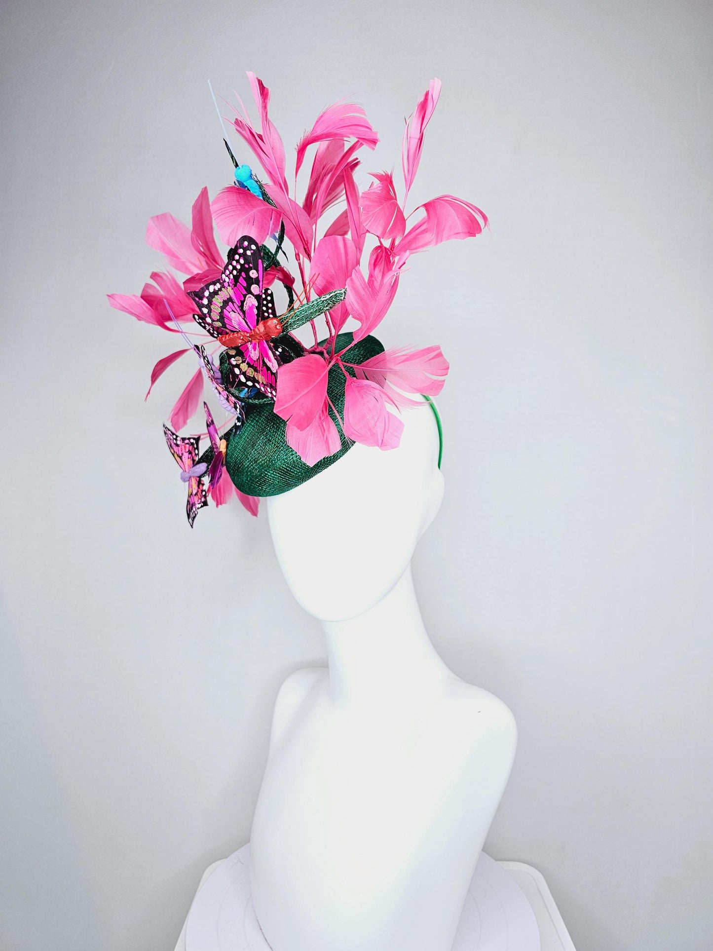 kentucky derby hat fascinator dark green sinamay with curls,pink branching feathers,colorful rainbow blue,pink,purple painted butterflies