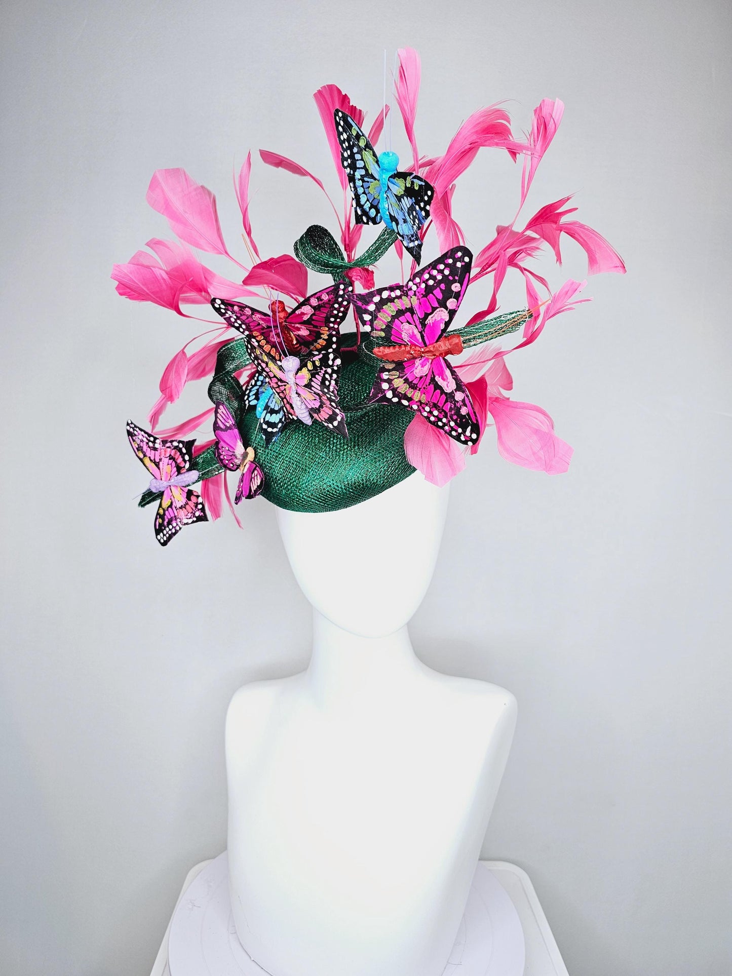 kentucky derby hat fascinator dark green sinamay with curls,pink branching feathers,colorful rainbow blue,pink,purple painted butterflies