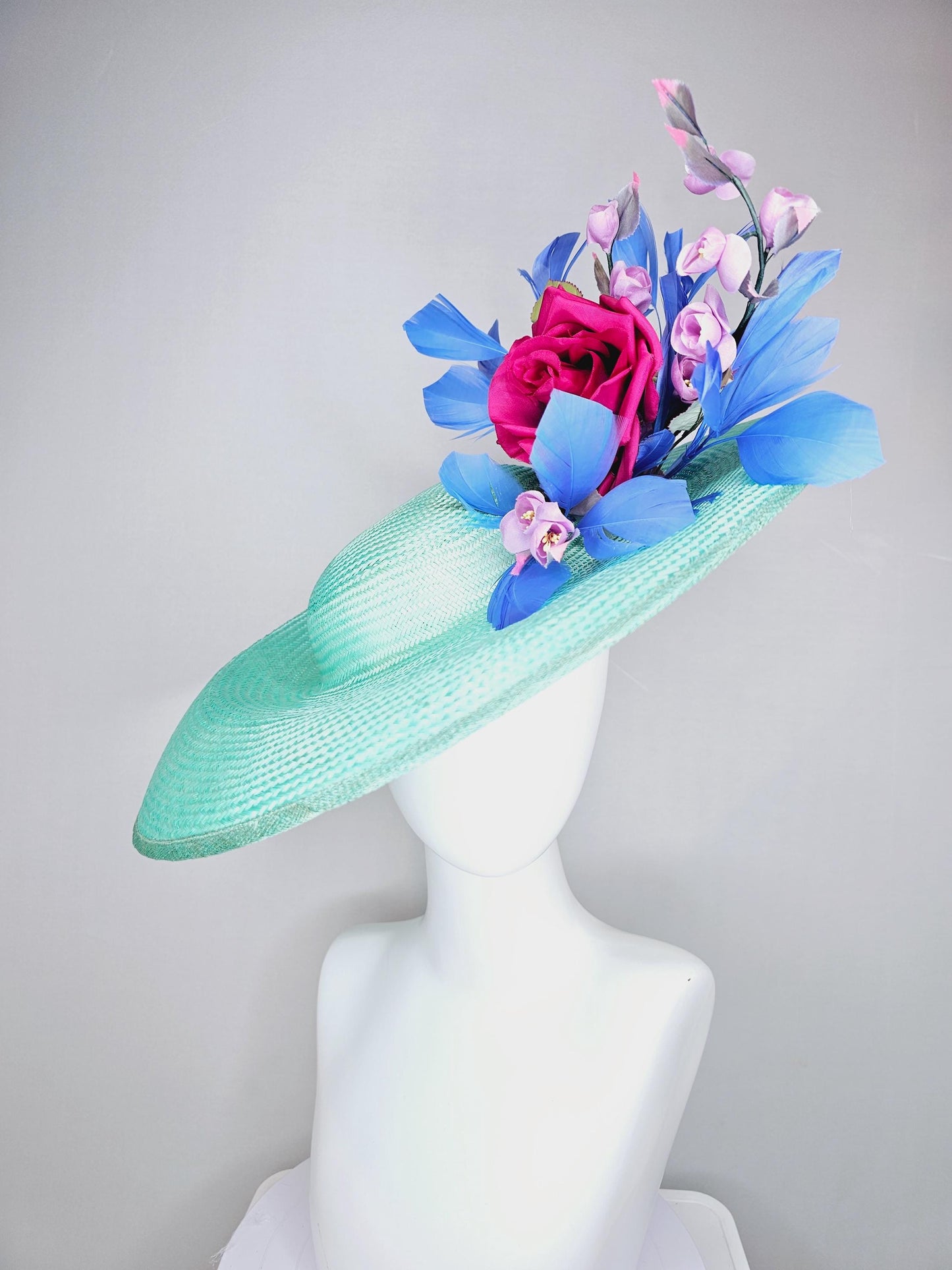 kentucky derby hat wide brim straw in aqua mint green with pink satin rose and lilac lavender purple satin rose stems cobalt blue feathers