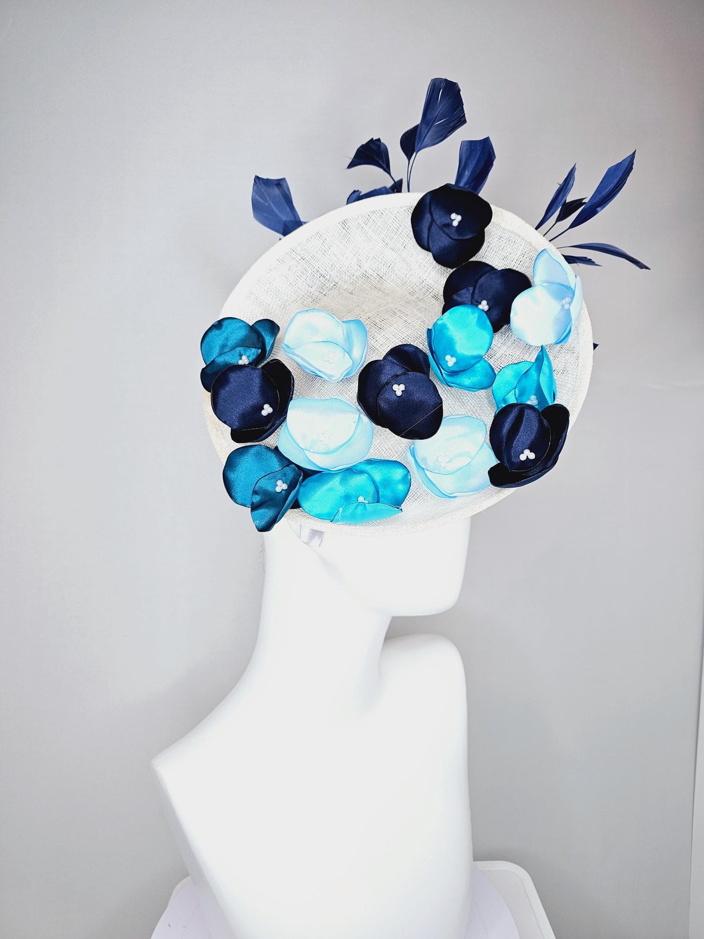 kentucky derby hat fascinator white sinamay saucer with light blue sky blue navy blue satin silk flowers and navy blue branching feathers