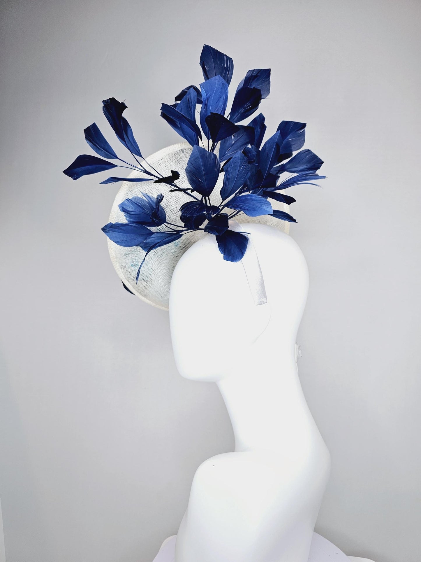 kentucky derby hat fascinator white sinamay saucer with light blue sky blue navy blue satin silk flowers and navy blue branching feathers