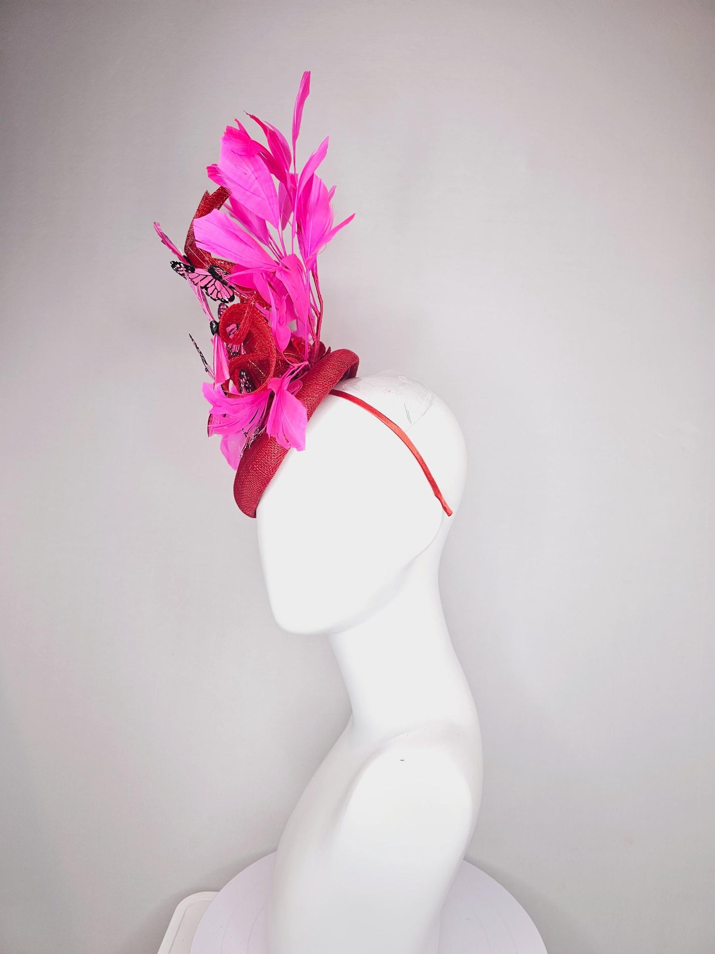 kentucky derby hat fascinator cherry red sinamay with curls hot pink fuchsia branching feathers and pink and black butterflies