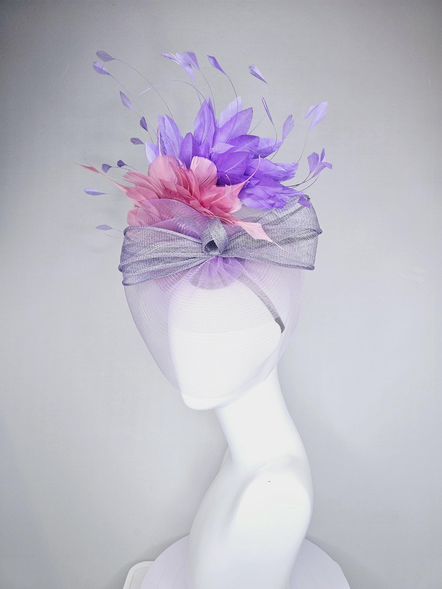 kentucky derby hat fascinator large purple sinamay bow with lavender and light pink branching feathers with purple mesh veil on a headband