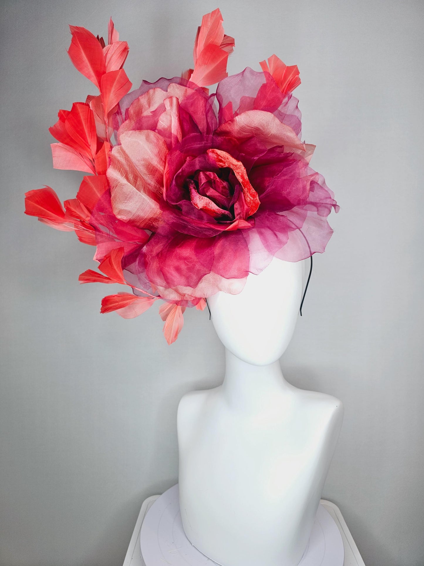 kentucky derby fascinator black headband with very large burgundy wine coral red organza flower and coral red branching feathers