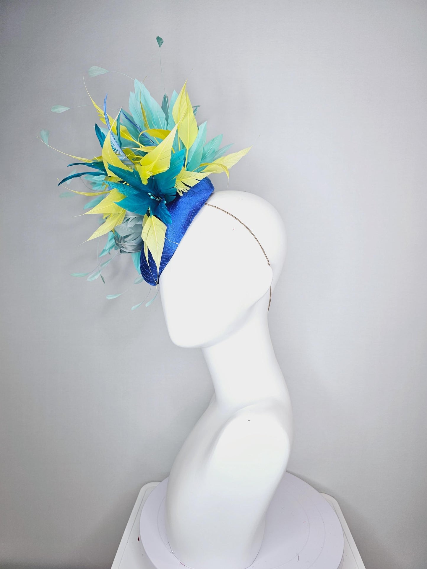 kentucky derby hat fascinator royal blue satin with netting light blue fluffy feather flower turquoise teal and yellow branching feathers