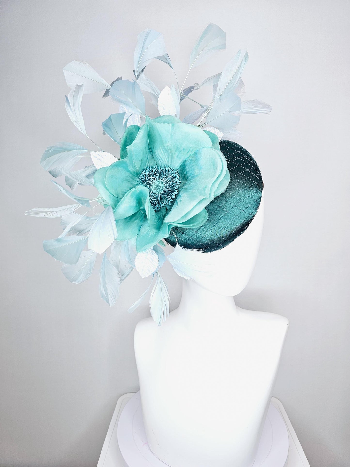 kentucky derby fascinator green satin with netting with large aqua blue silk flower with beaded core white velvet leaves light blue feathers