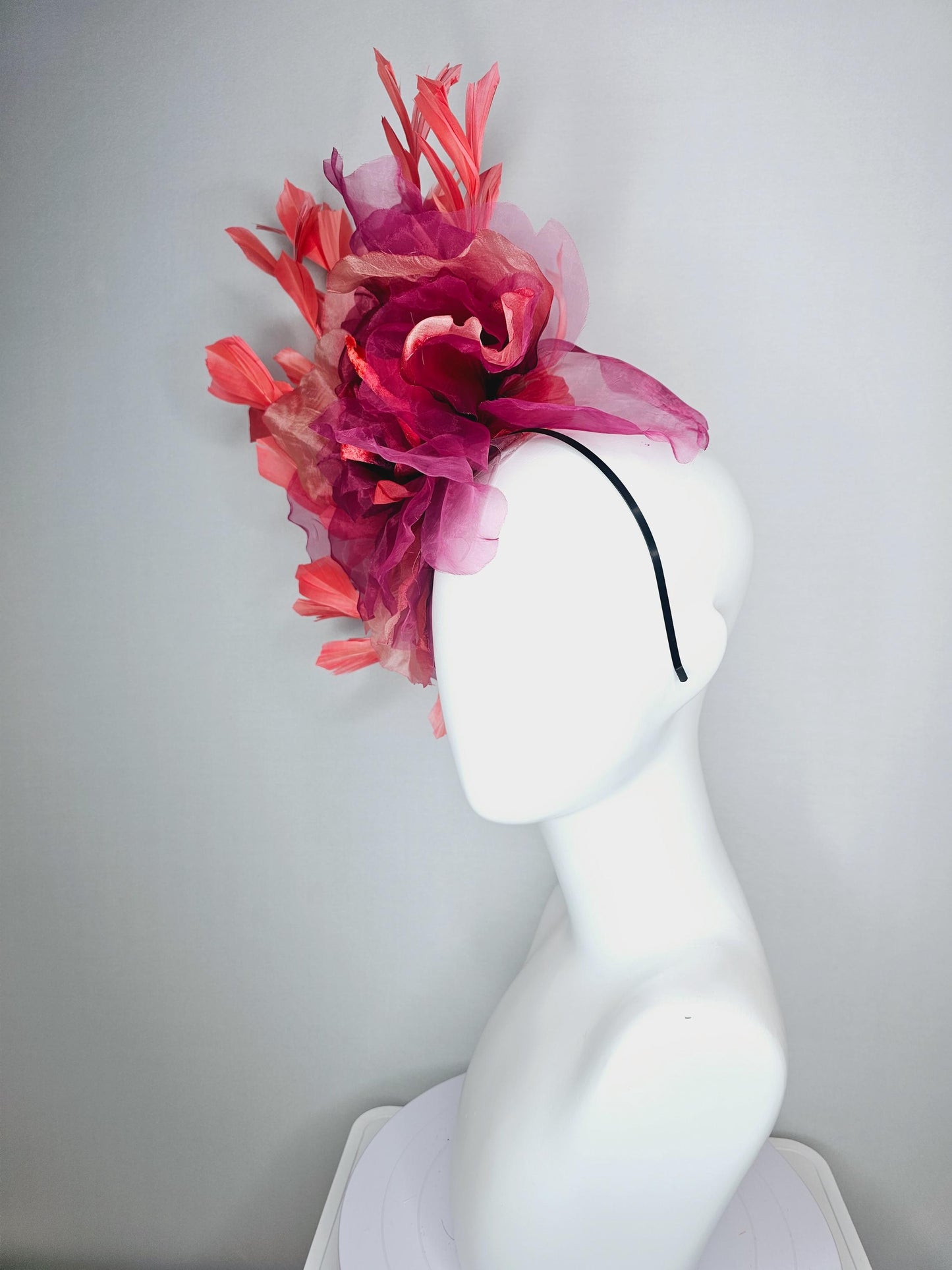 kentucky derby fascinator black headband with very large burgundy wine coral red organza flower and coral red branching feathers
