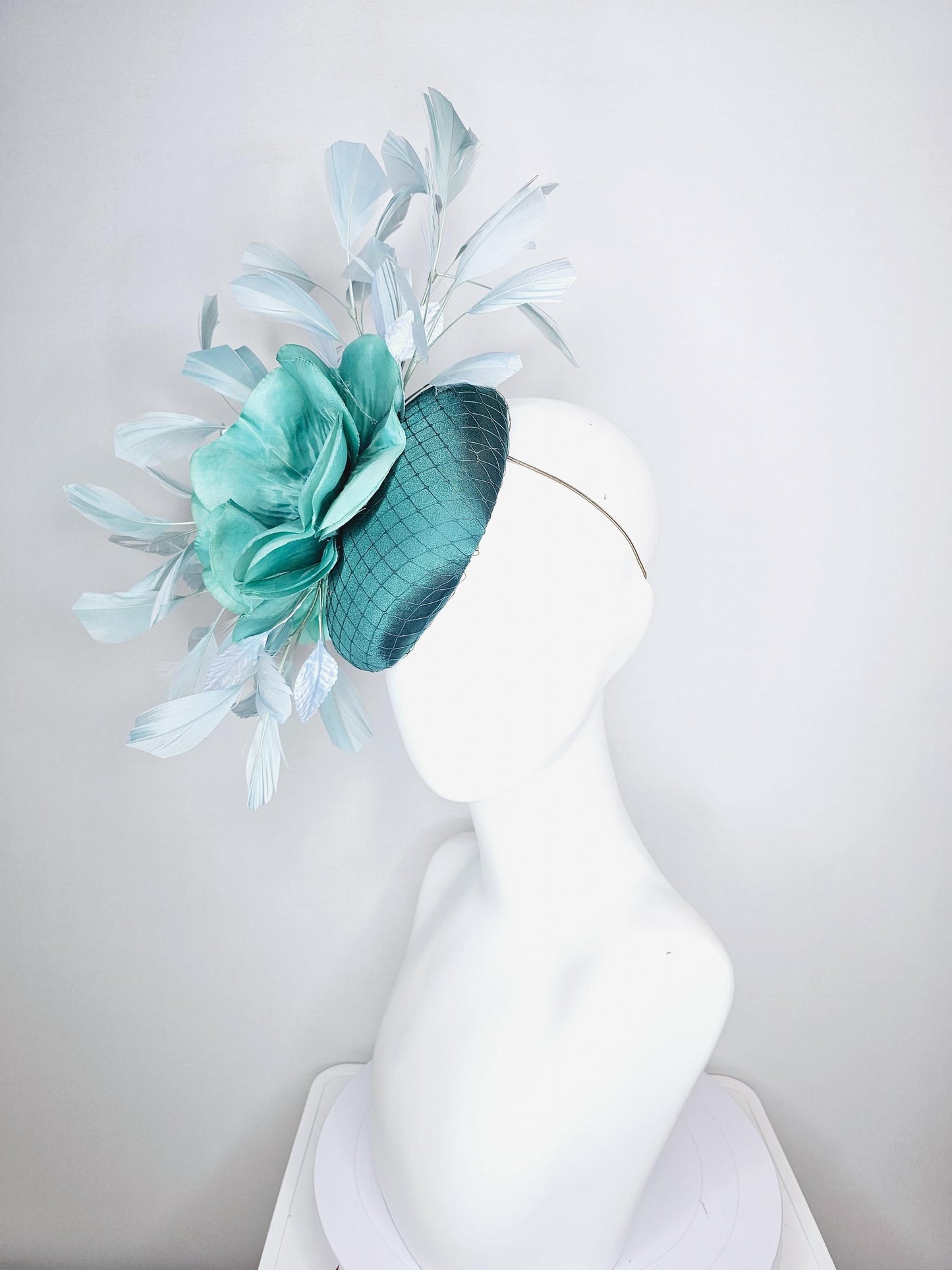 kentucky derby fascinator green satin with netting with large aqua blue silk flower with beaded core white velvet leaves light blue feathers