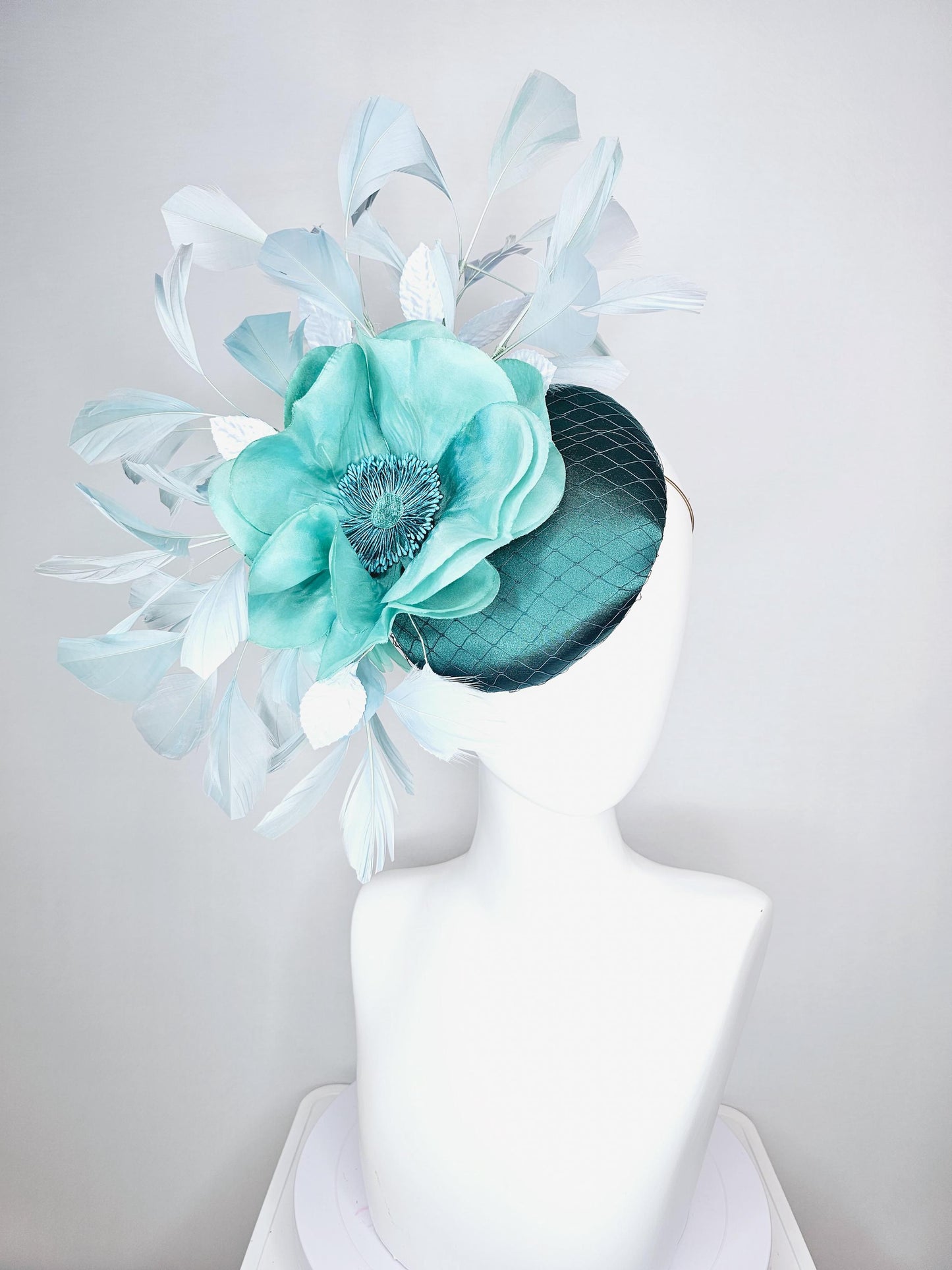 kentucky derby fascinator green satin with netting with large aqua blue silk flower with beaded core white velvet leaves light blue feathers
