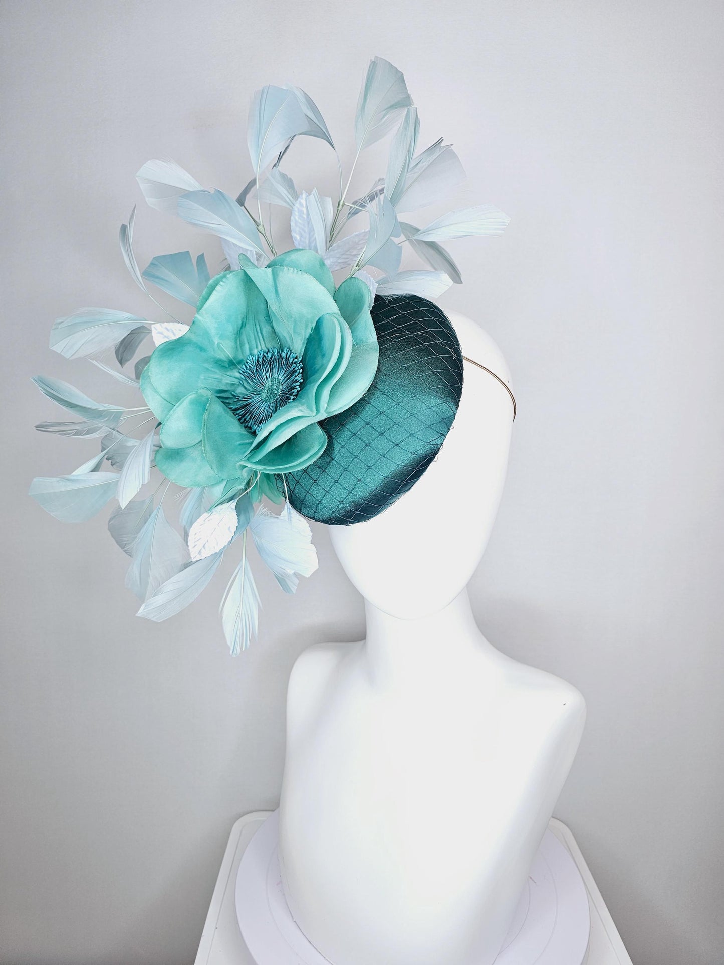 kentucky derby fascinator green satin with netting with large aqua blue silk flower with beaded core white velvet leaves light blue feathers