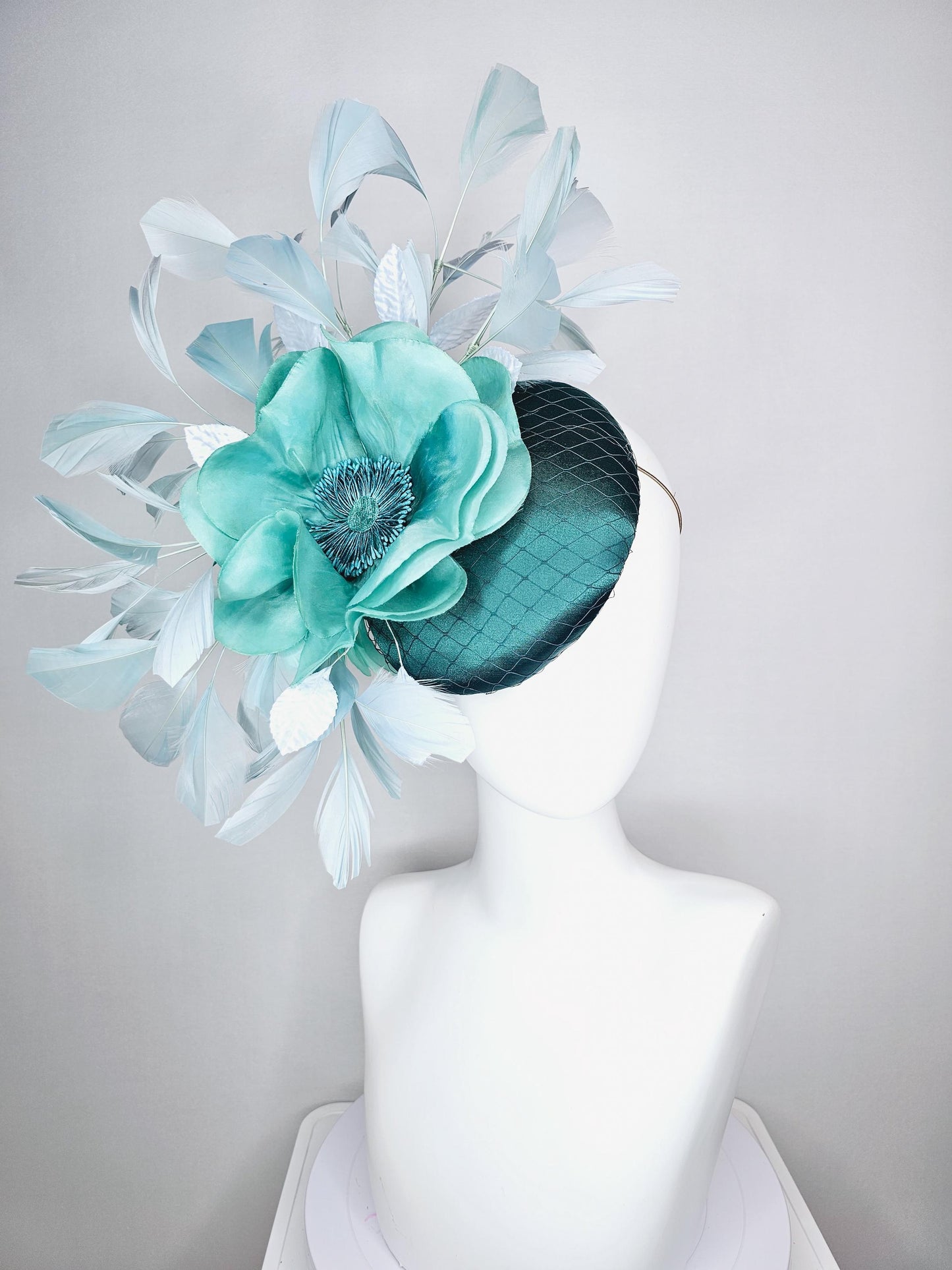 kentucky derby fascinator green satin with netting with large aqua blue silk flower with beaded core white velvet leaves light blue feathers