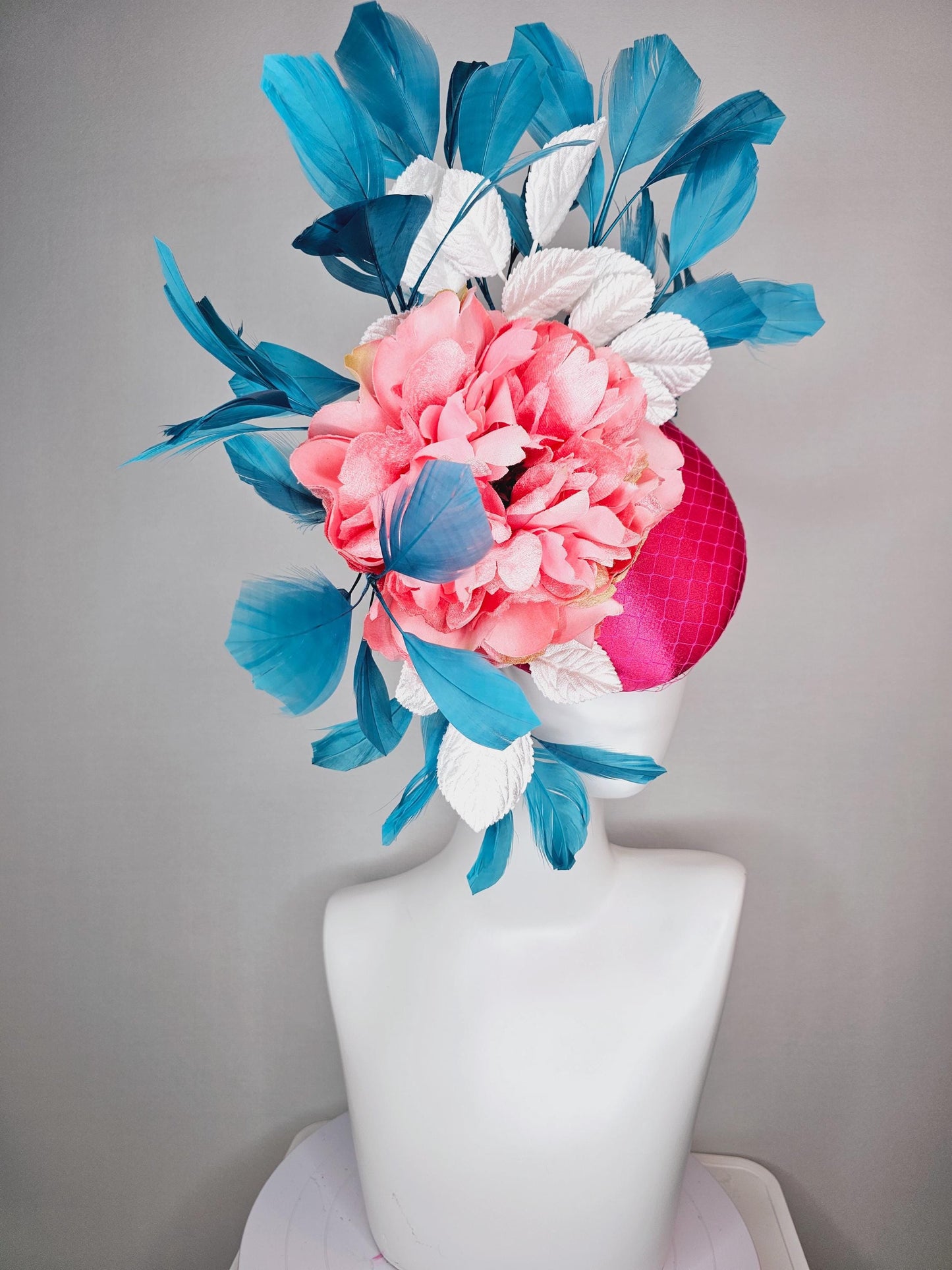 kentucky derby hat fascinator hot pink satin with netting and light pink peony satin flower with white leaves and blue branching feathers