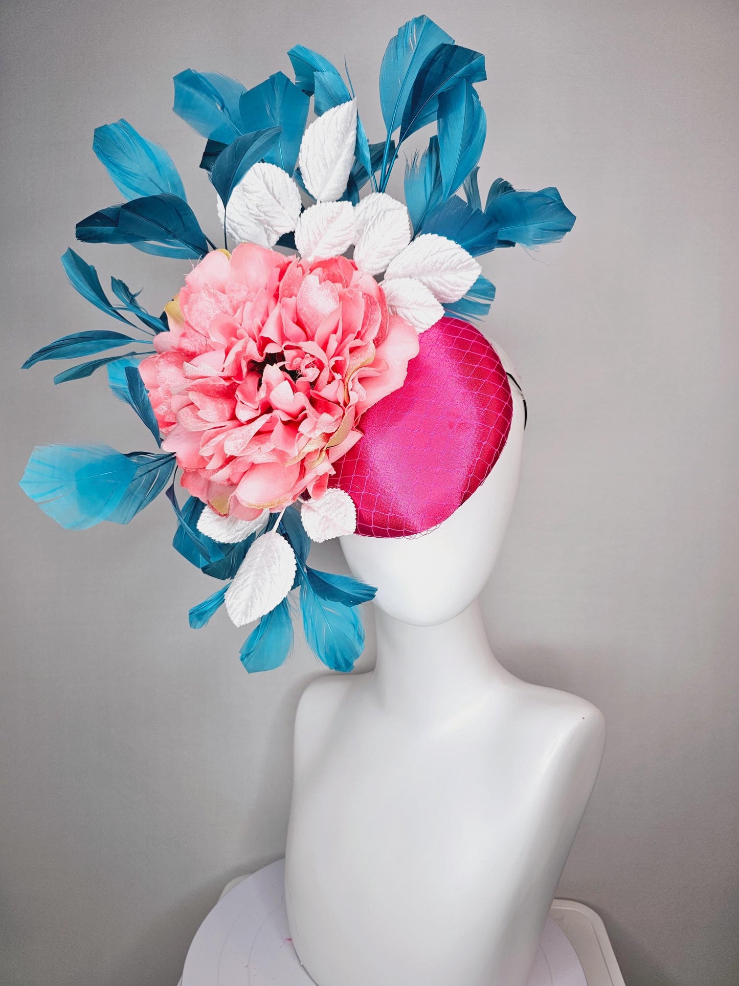 kentucky derby hat fascinator hot pink satin with netting and light pink peony satin flower with white leaves and blue branching feathers