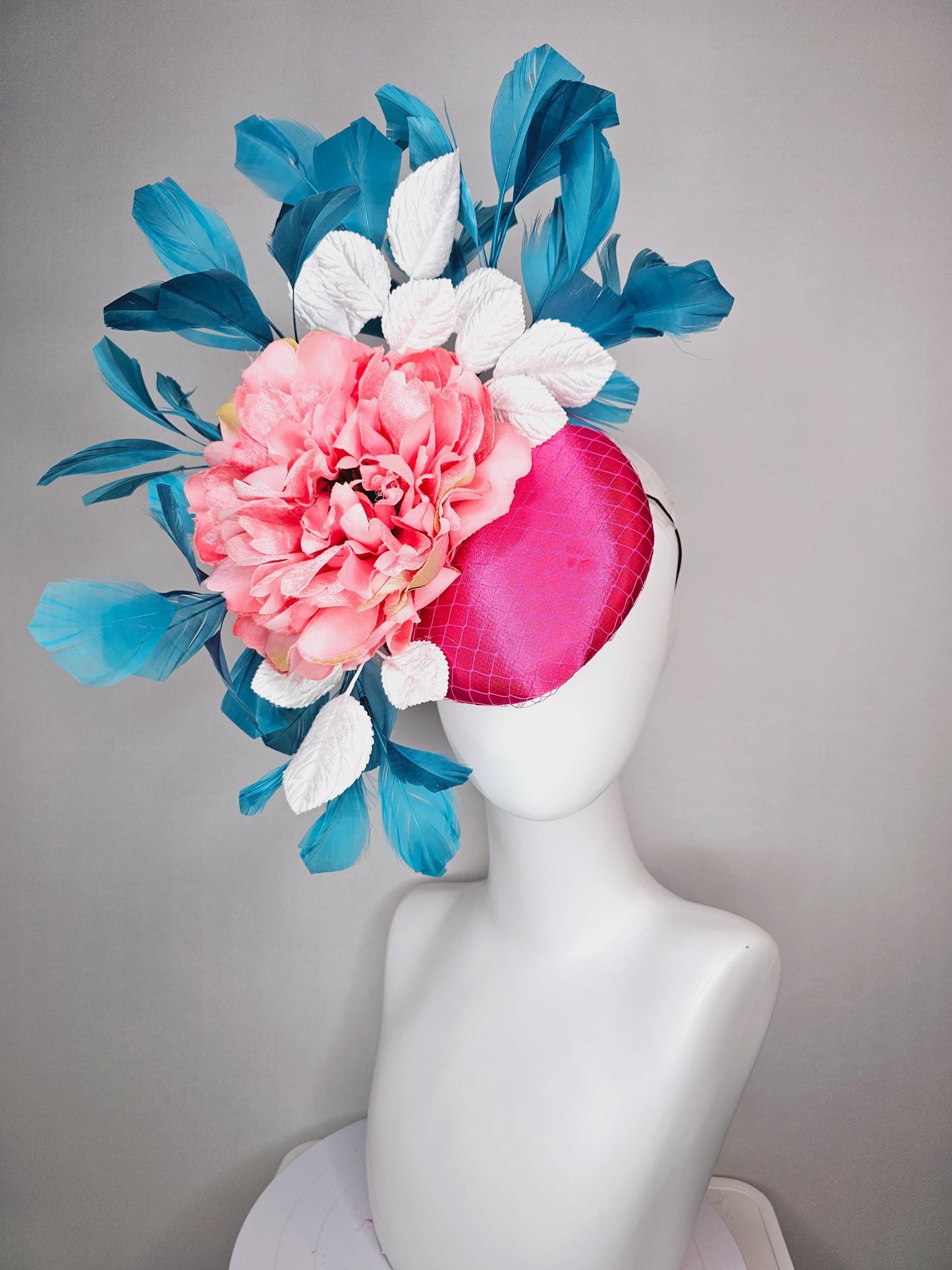 kentucky derby hat fascinator hot pink satin with netting and light pink peony satin flower with white leaves and blue branching feathers