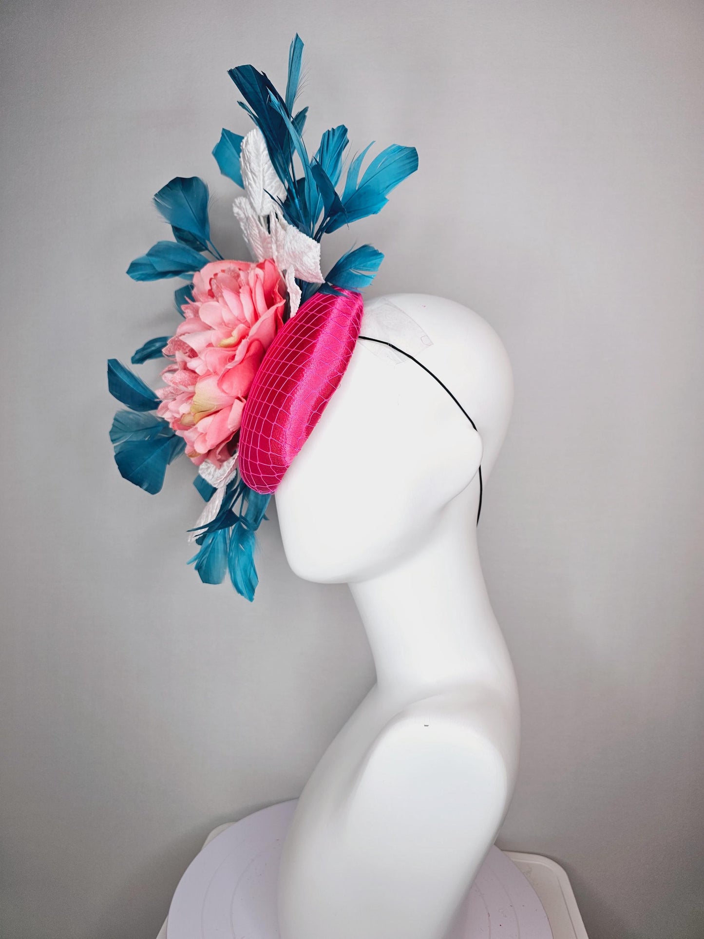 kentucky derby hat fascinator hot pink satin with netting and light pink peony satin flower with white leaves and blue branching feathers