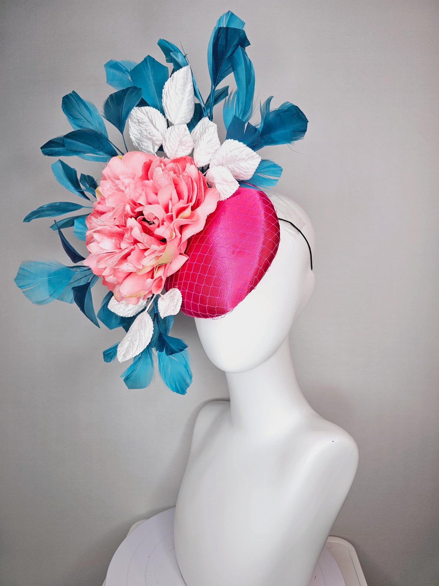 kentucky derby hat fascinator hot pink satin with netting and light pink peony satin flower with white leaves and blue branching feathers