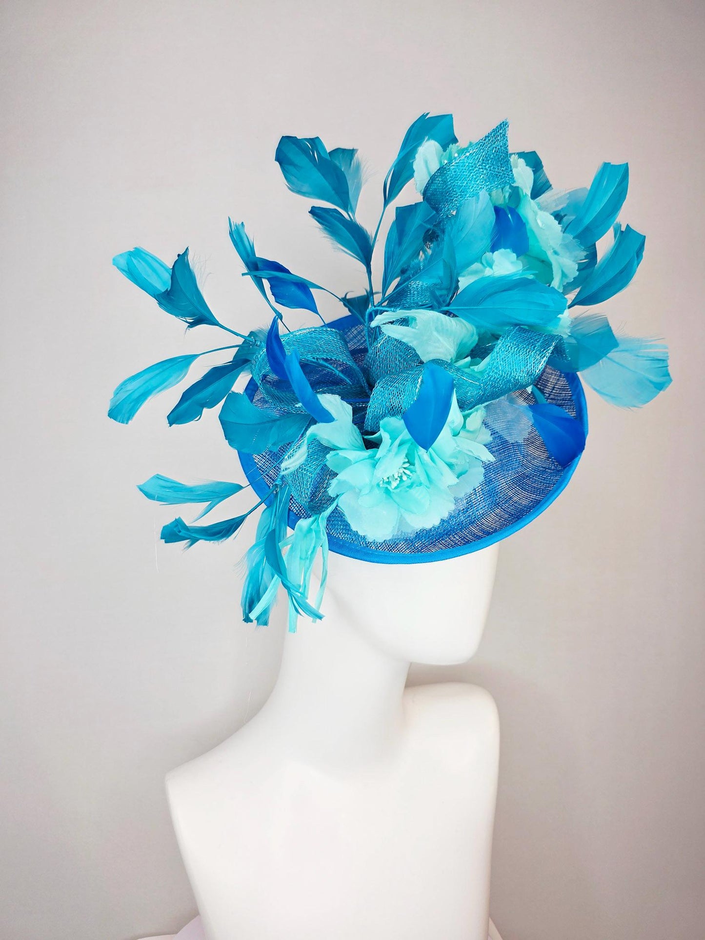 kentucky derby hat fascinator turquoise blue sinamay saucer with bow aqua blue organza satin flowers sky and royal blue branching feathers