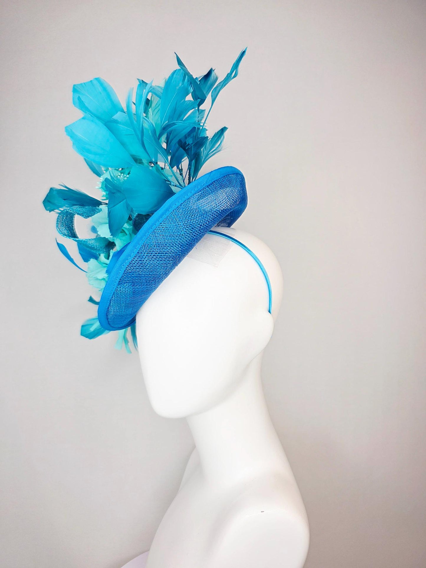 kentucky derby hat fascinator turquoise blue sinamay saucer with bow aqua blue organza satin flowers sky and royal blue branching feathers