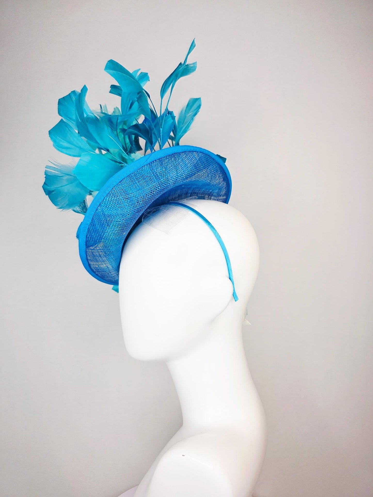 kentucky derby hat fascinator turquoise blue sinamay saucer with bow aqua blue organza satin flowers sky and royal blue branching feathers