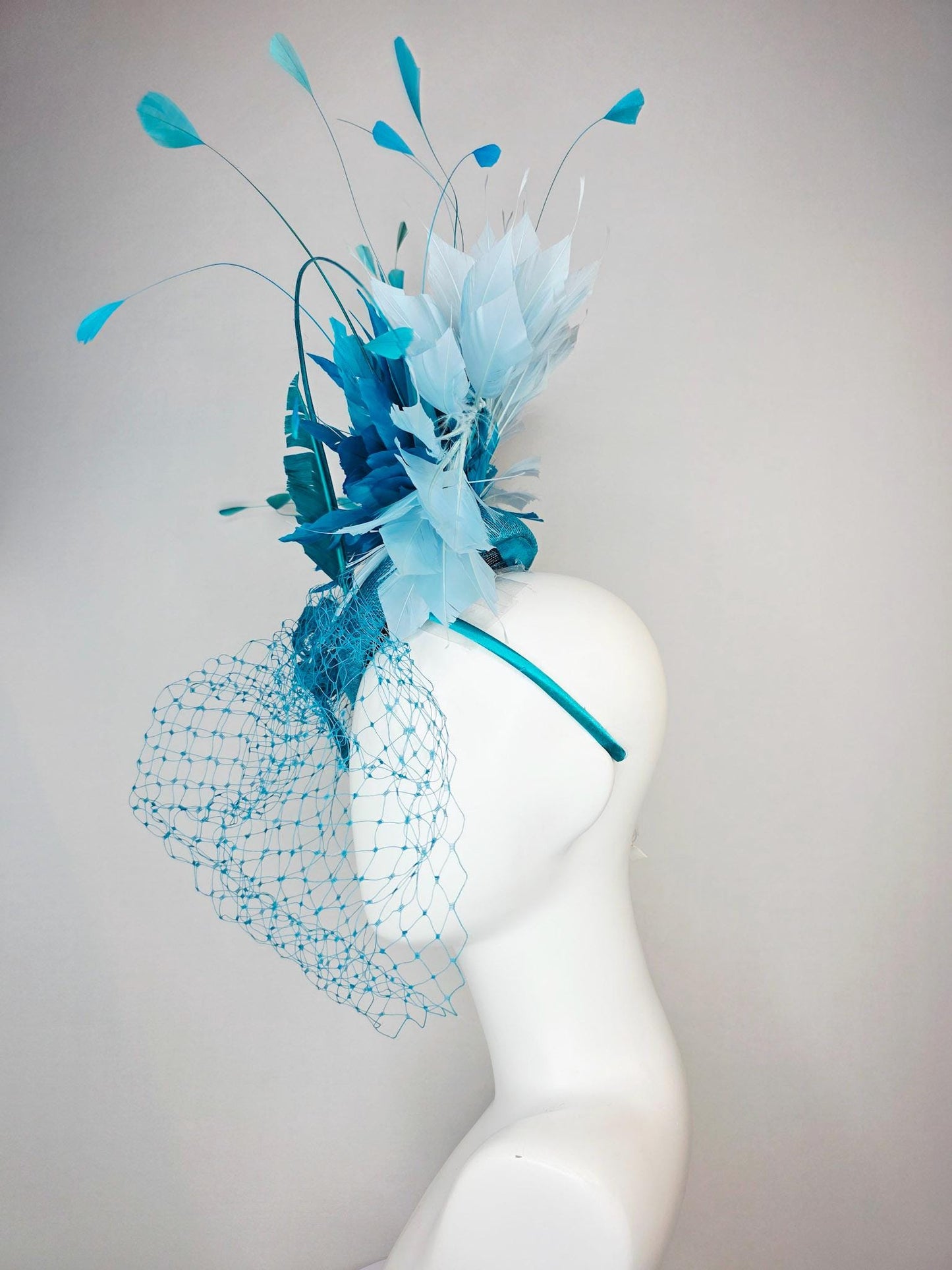 kentucky derby hat fascinator sky blue sinamay with sinamay bow and sky teal and light blue feathers and blue mesh veil