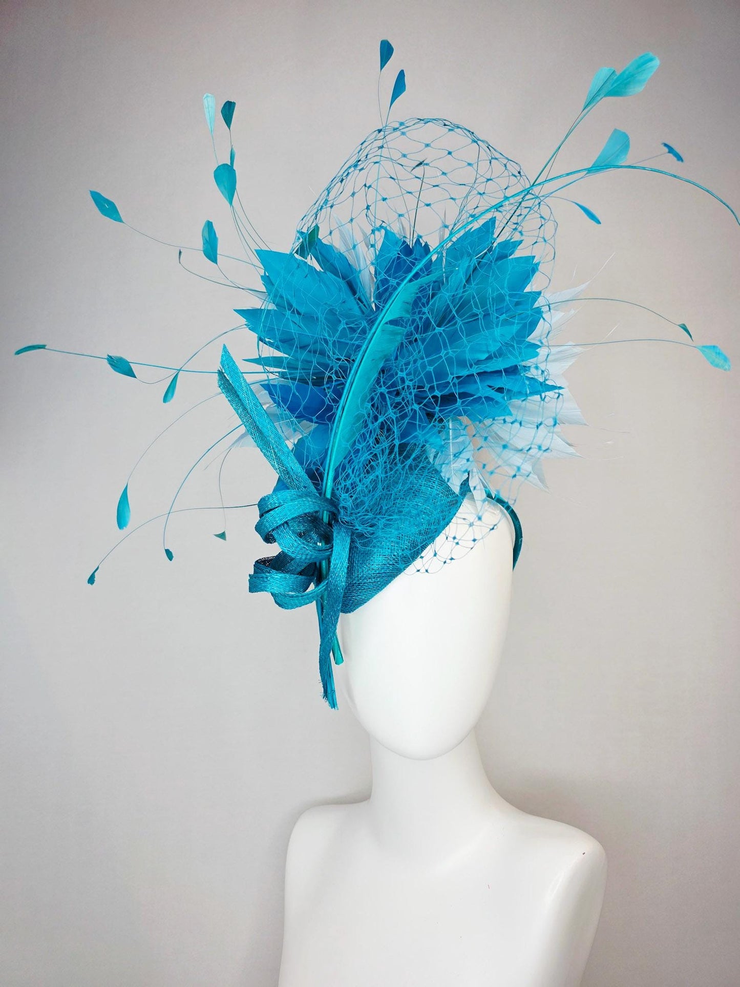 kentucky derby hat fascinator sky blue sinamay with sinamay bow and sky teal and light blue feathers and blue mesh veil