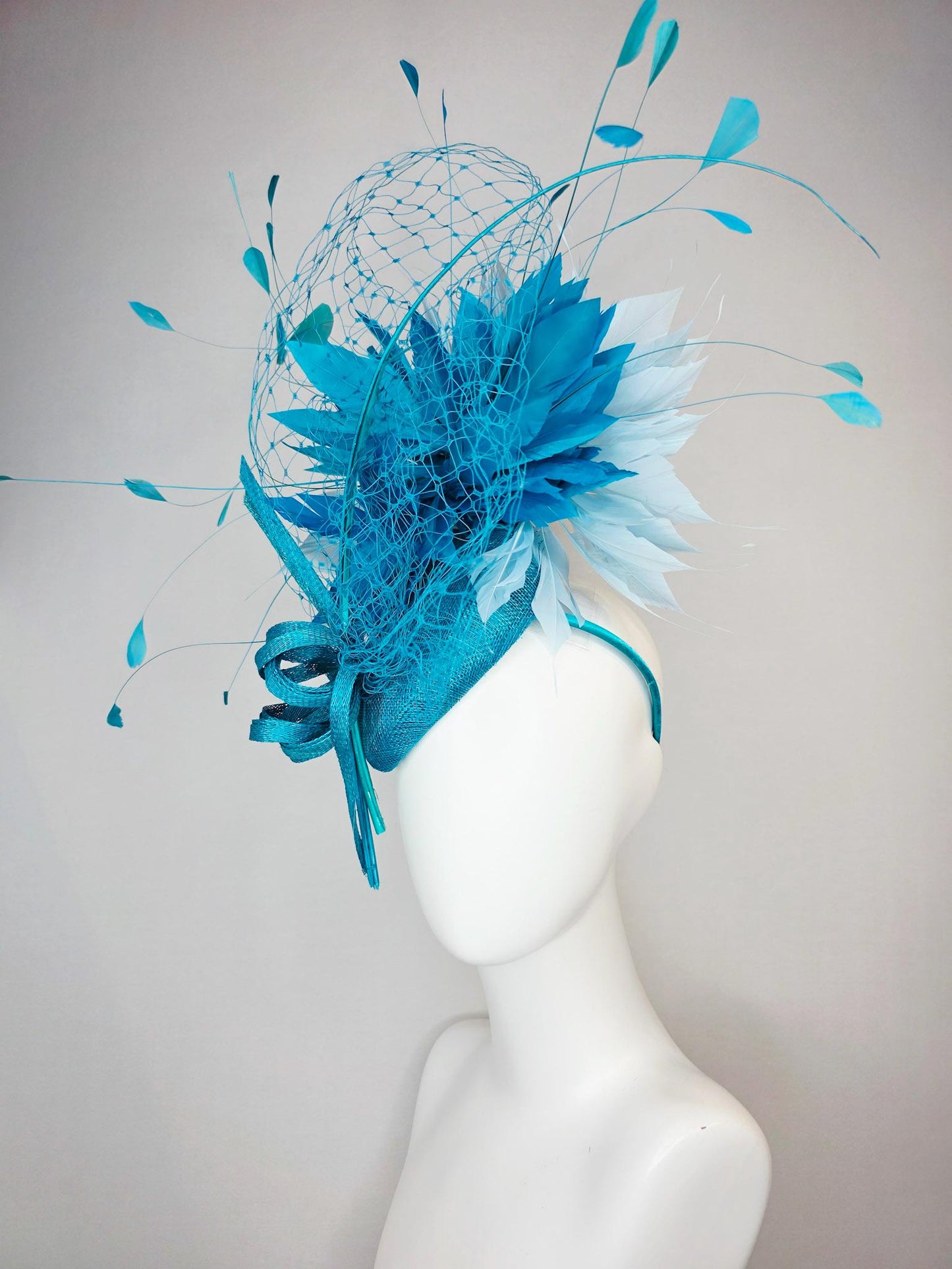 kentucky derby hat fascinator sky blue sinamay with sinamay bow and sky teal and light blue feathers and blue mesh veil
