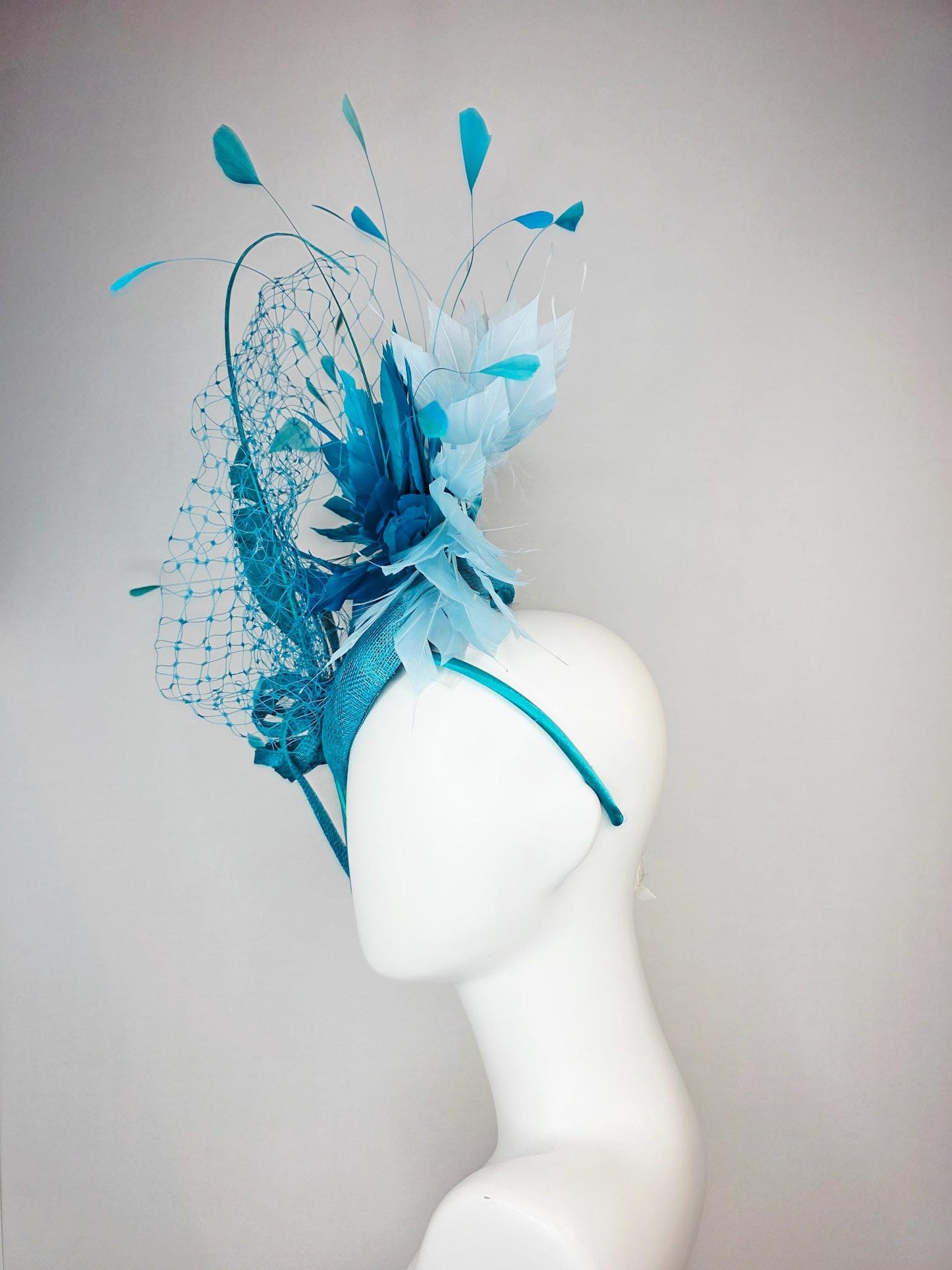 kentucky derby hat fascinator sky blue sinamay with sinamay bow and sky teal and light blue feathers and blue mesh veil