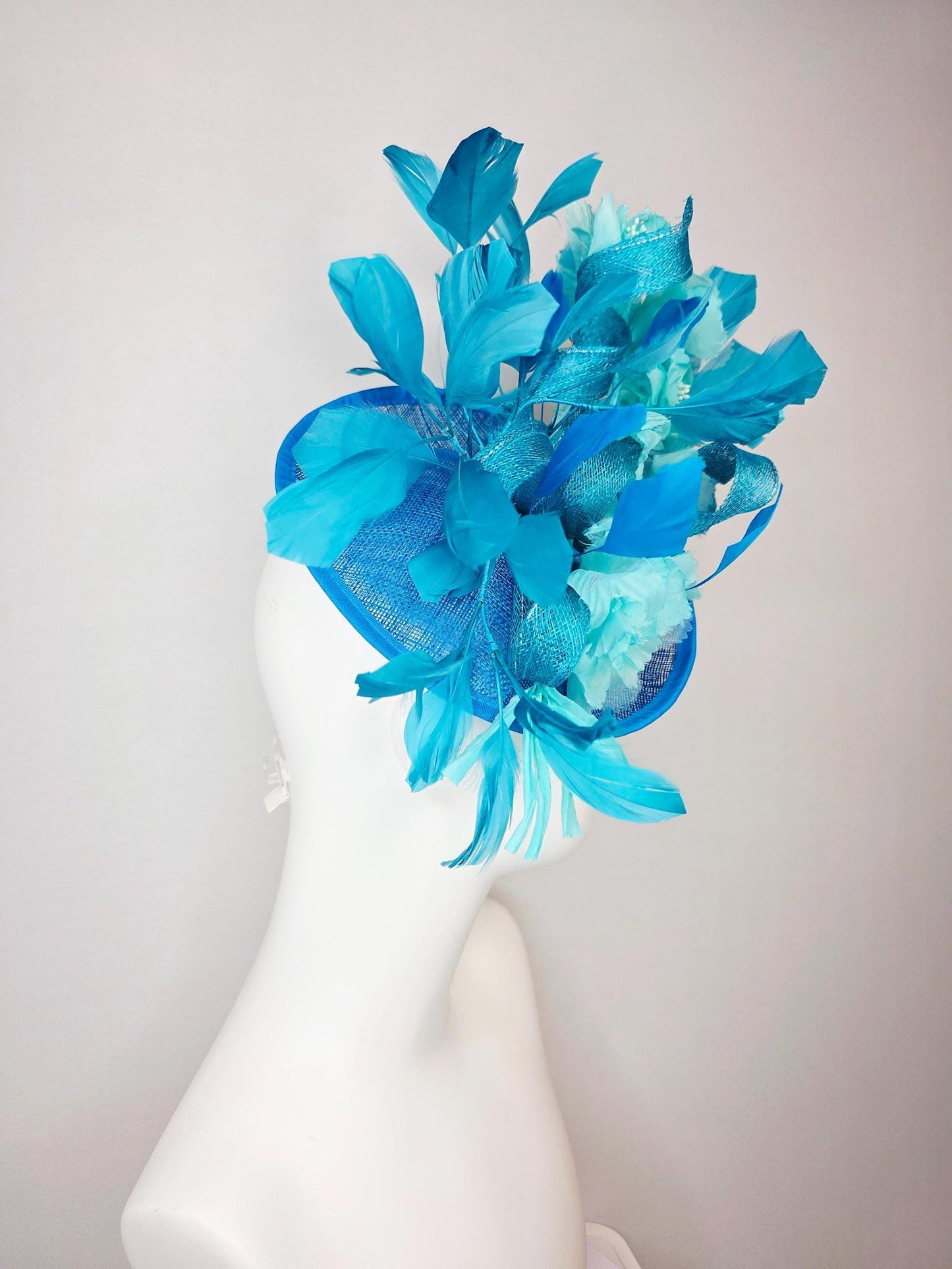 kentucky derby hat fascinator turquoise blue sinamay saucer with bow aqua blue organza satin flowers sky and royal blue branching feathers