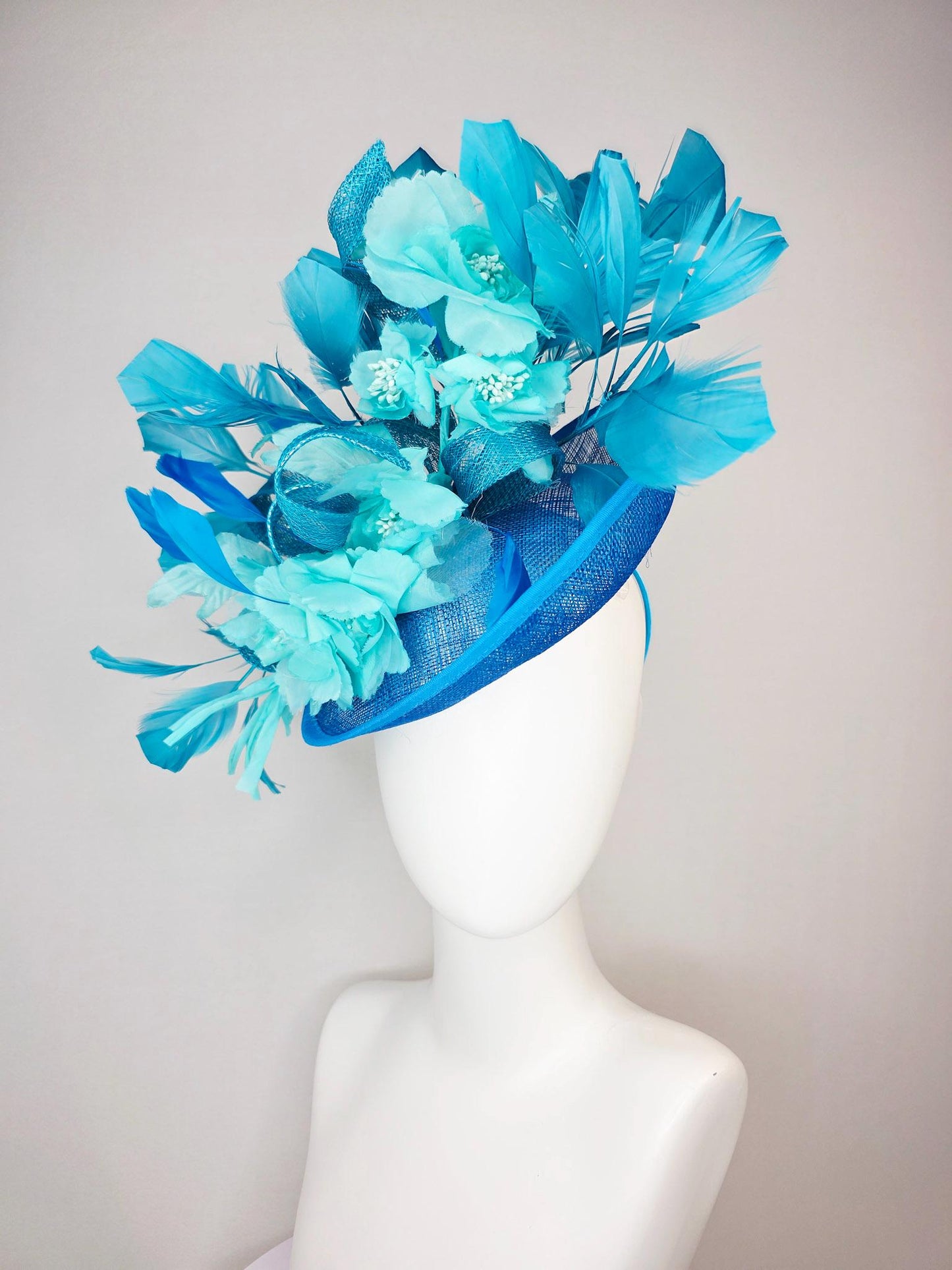 kentucky derby hat fascinator turquoise blue sinamay saucer with bow aqua blue organza satin flowers sky and royal blue branching feathers