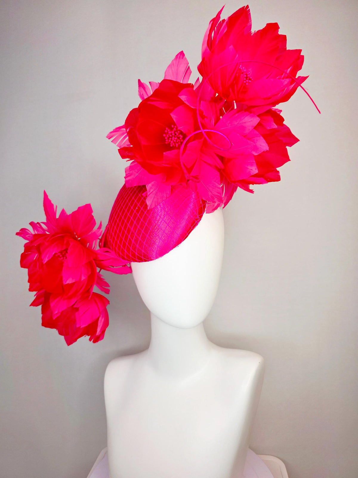 kentucky derby hat fascinator hot raspberry pink satin with netting and large fluffy red feather flowers with fuchsia pink feathers